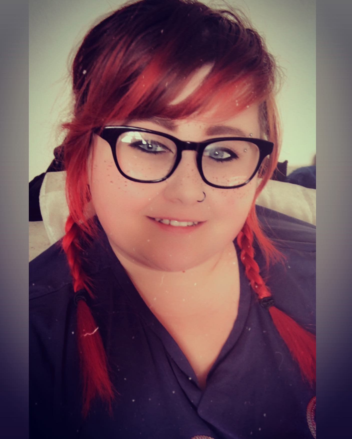 Low red braided pigtails with a side-swept fringe