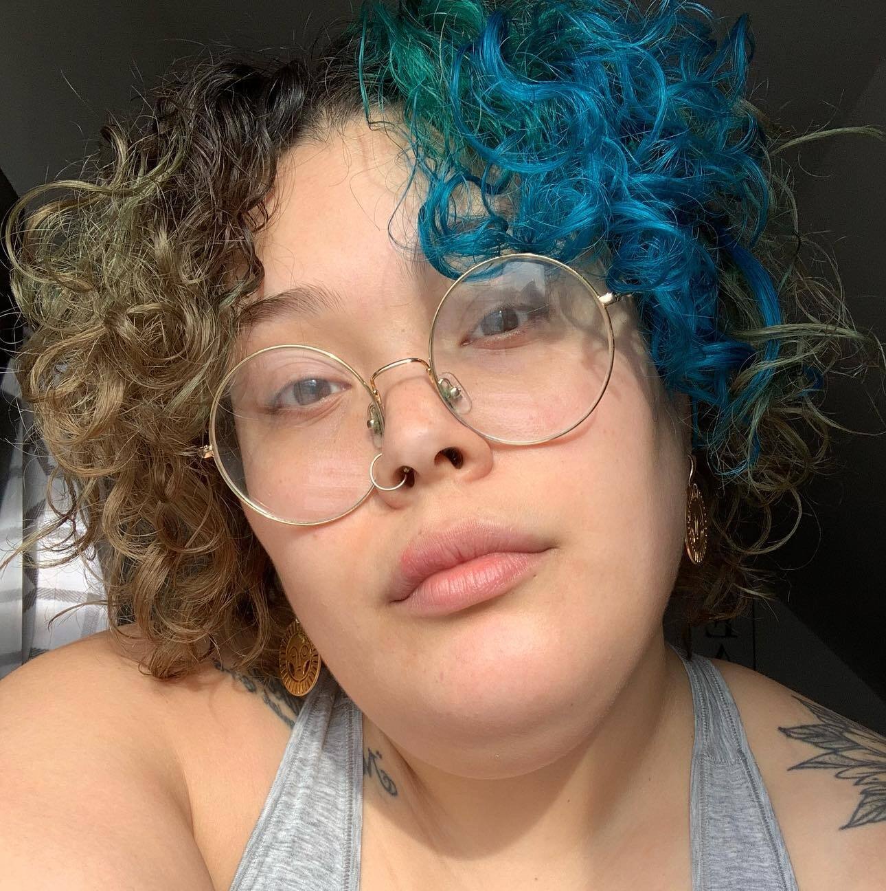 Asymmetrical curly bob with blue curls and warm-toned sections