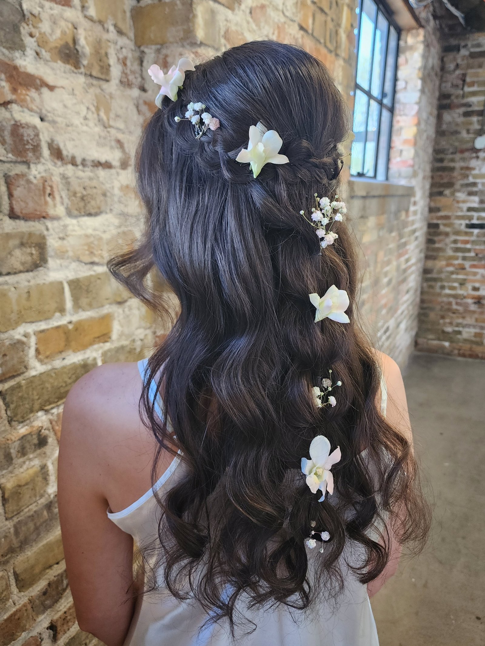 Half-up braid with orchid flowers baby's breath and long waves