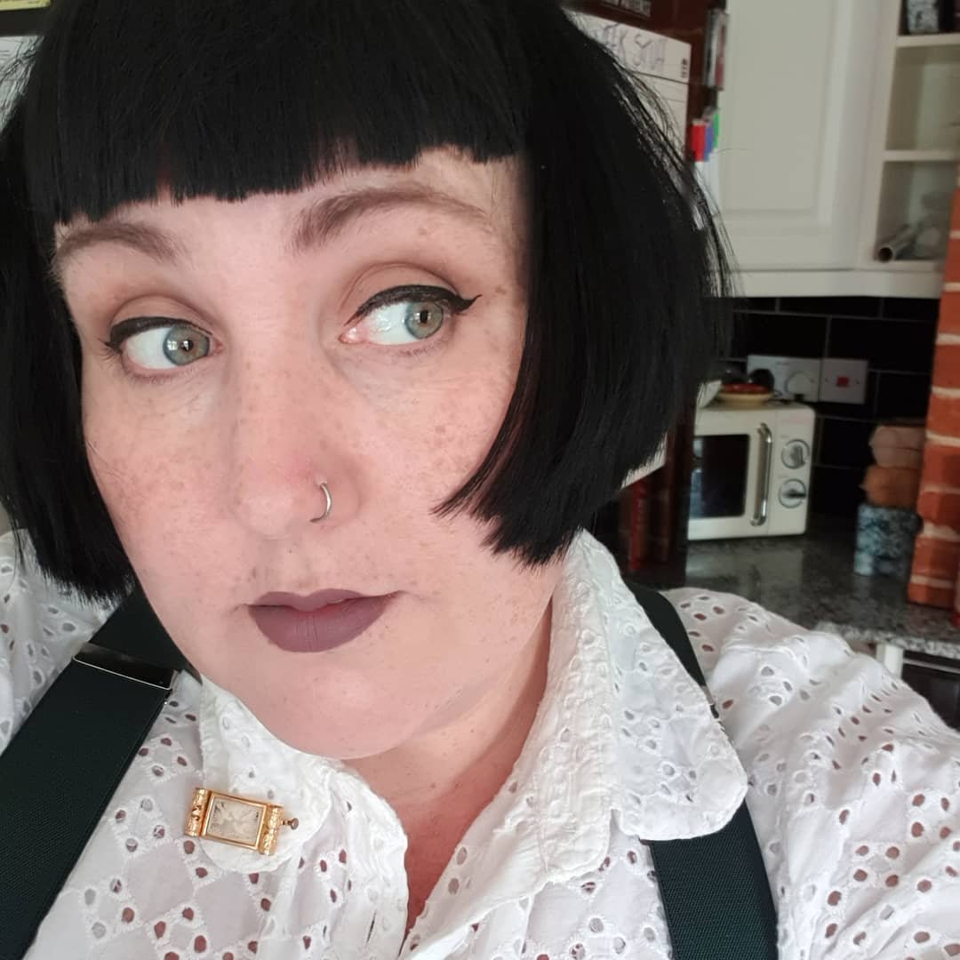 Sleek black blunt bob with a straight micro fringe and jaw-length ends