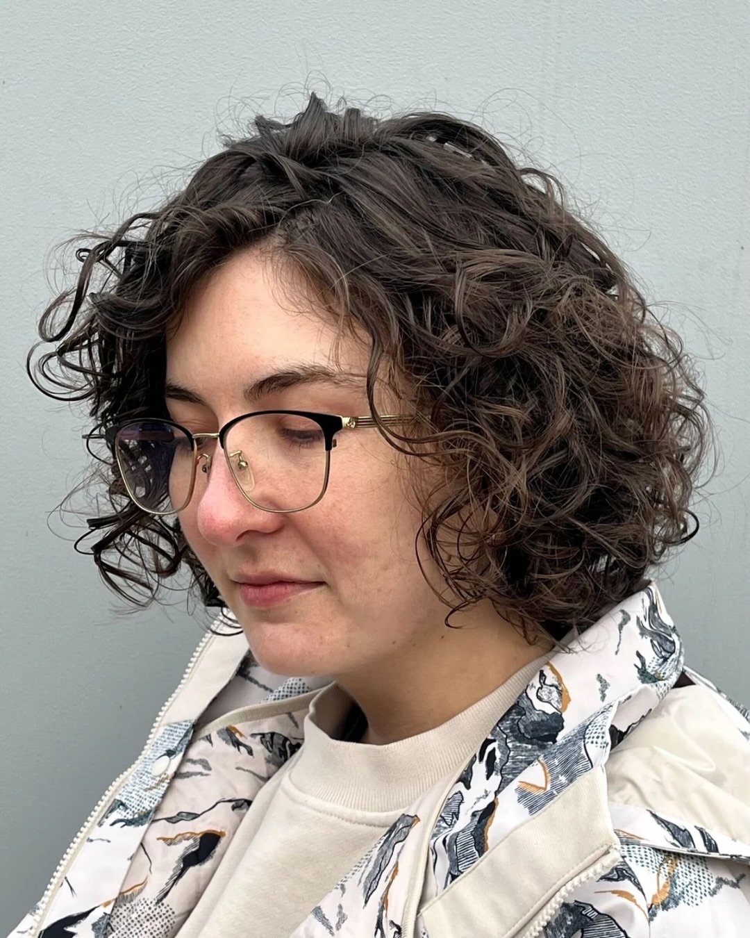 Defined curly bob with a side part and rounded chin-length shape