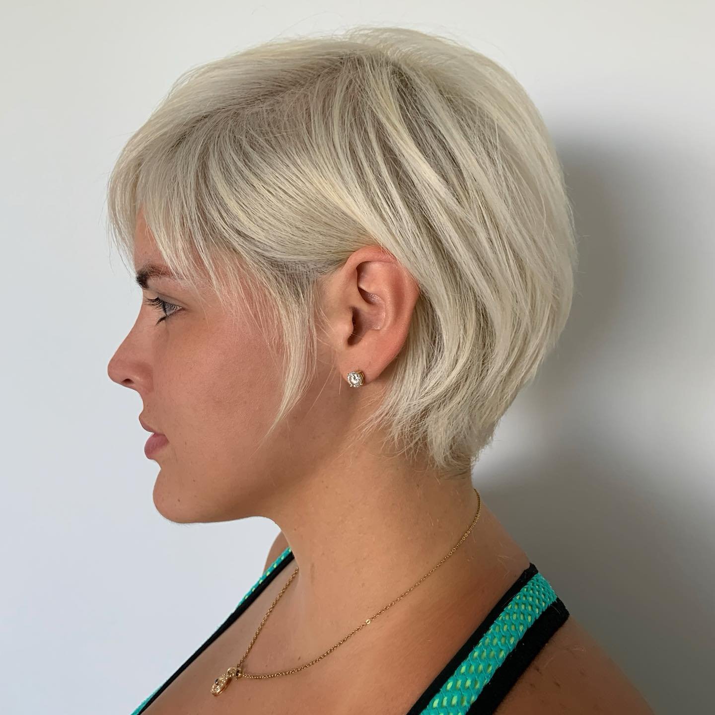 Smooth platinum pixie bob with a side fringe and tapered neckline