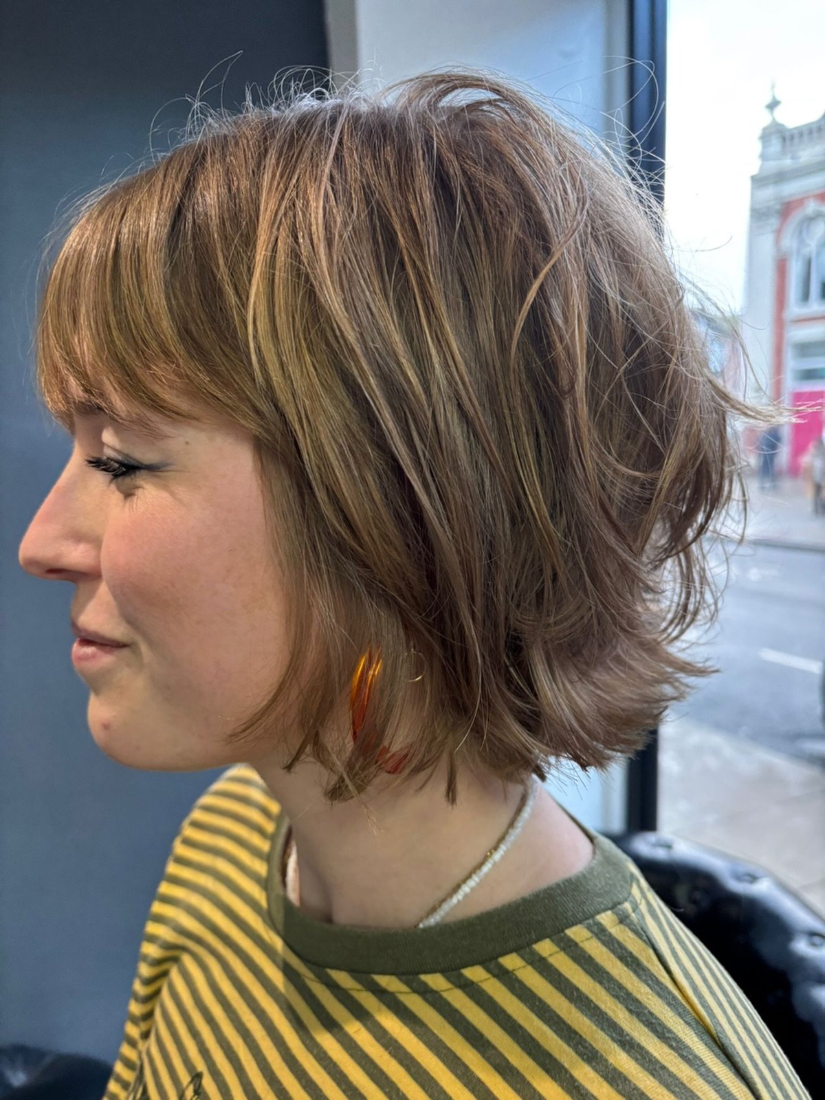 Highlighted layered pixie bob with wispy fringe and flicked ends