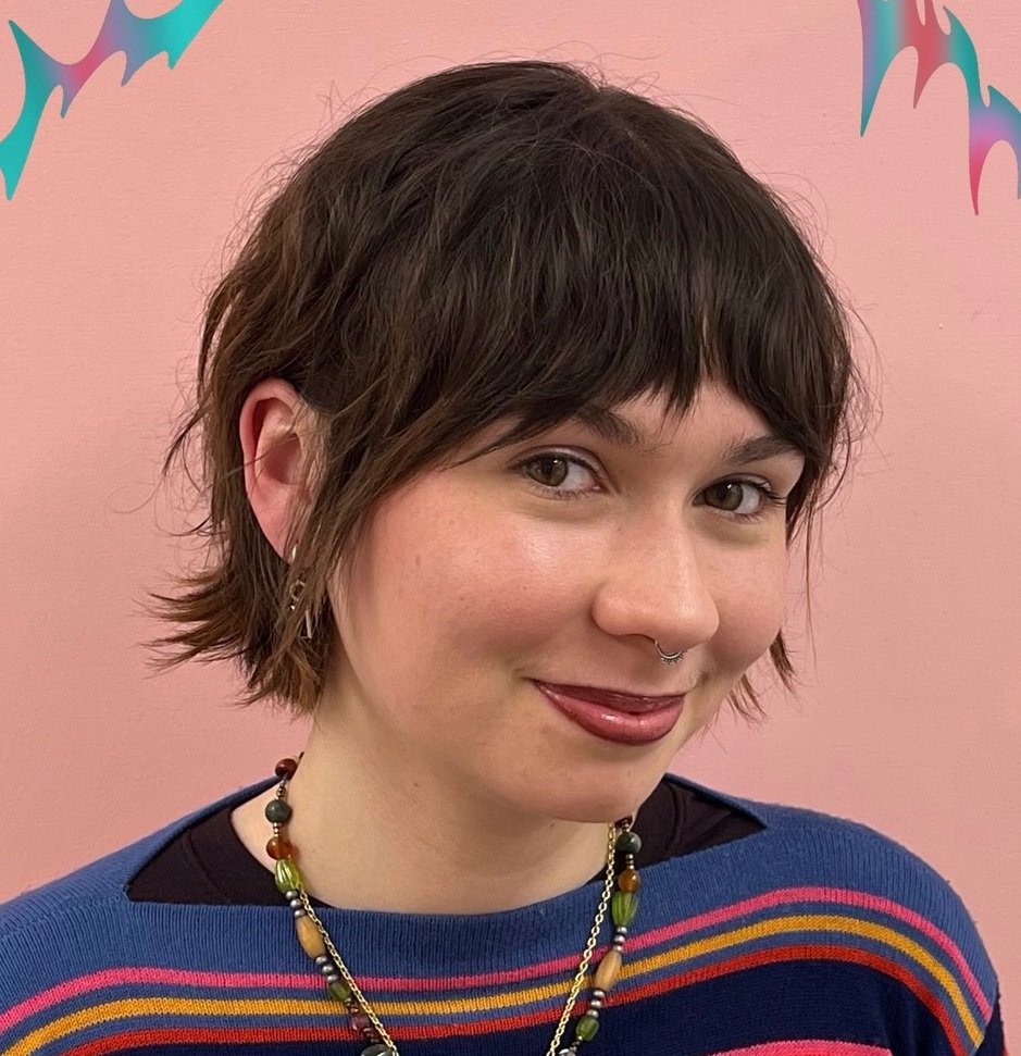 Dark shaggy bixie haircut with a short fringe and flicked nape
