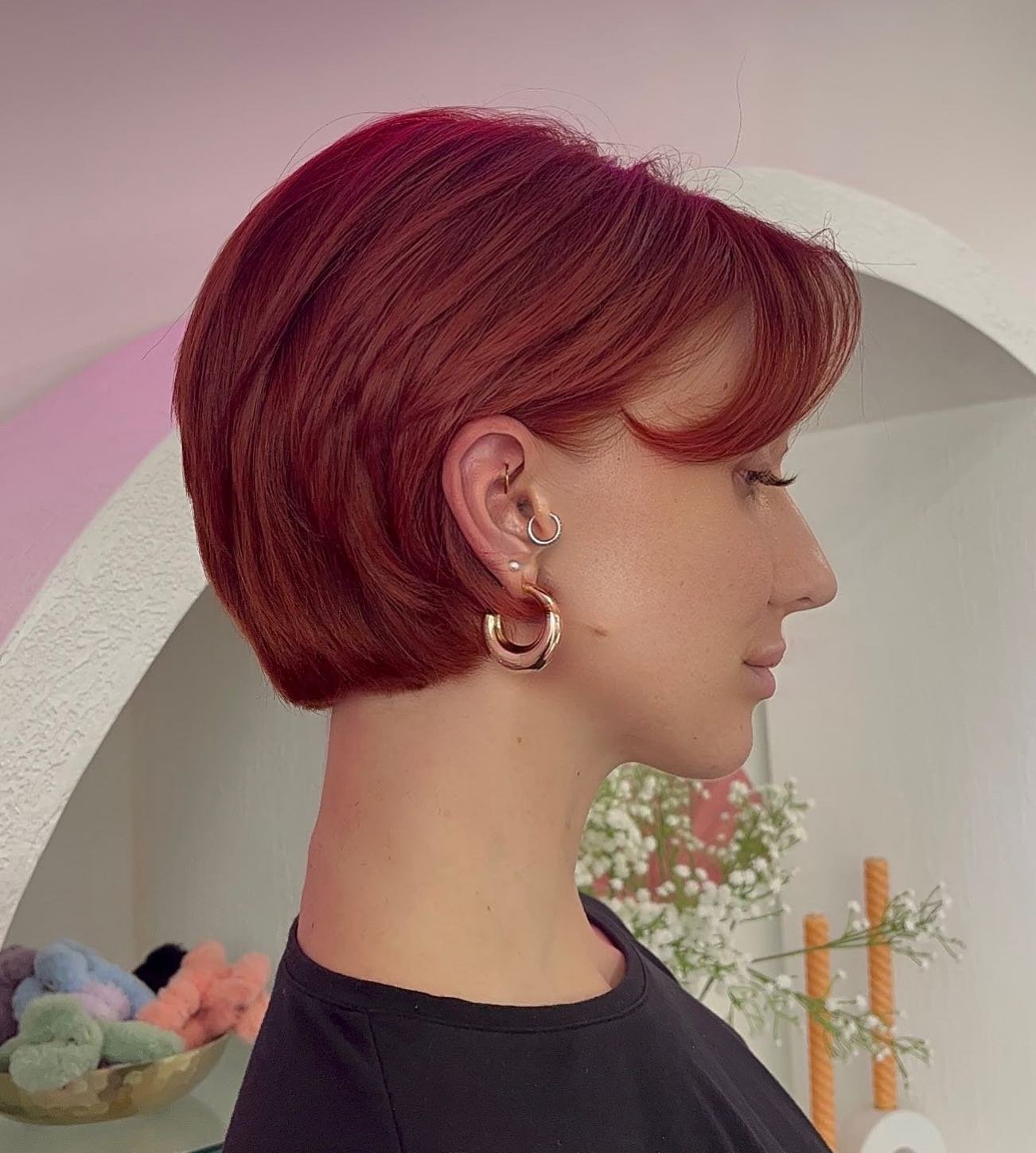 Sleek red pixie bob with a deep side-swept fringe