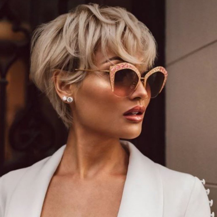 Blonde voluminous pixie bob with a long sweeping fringe