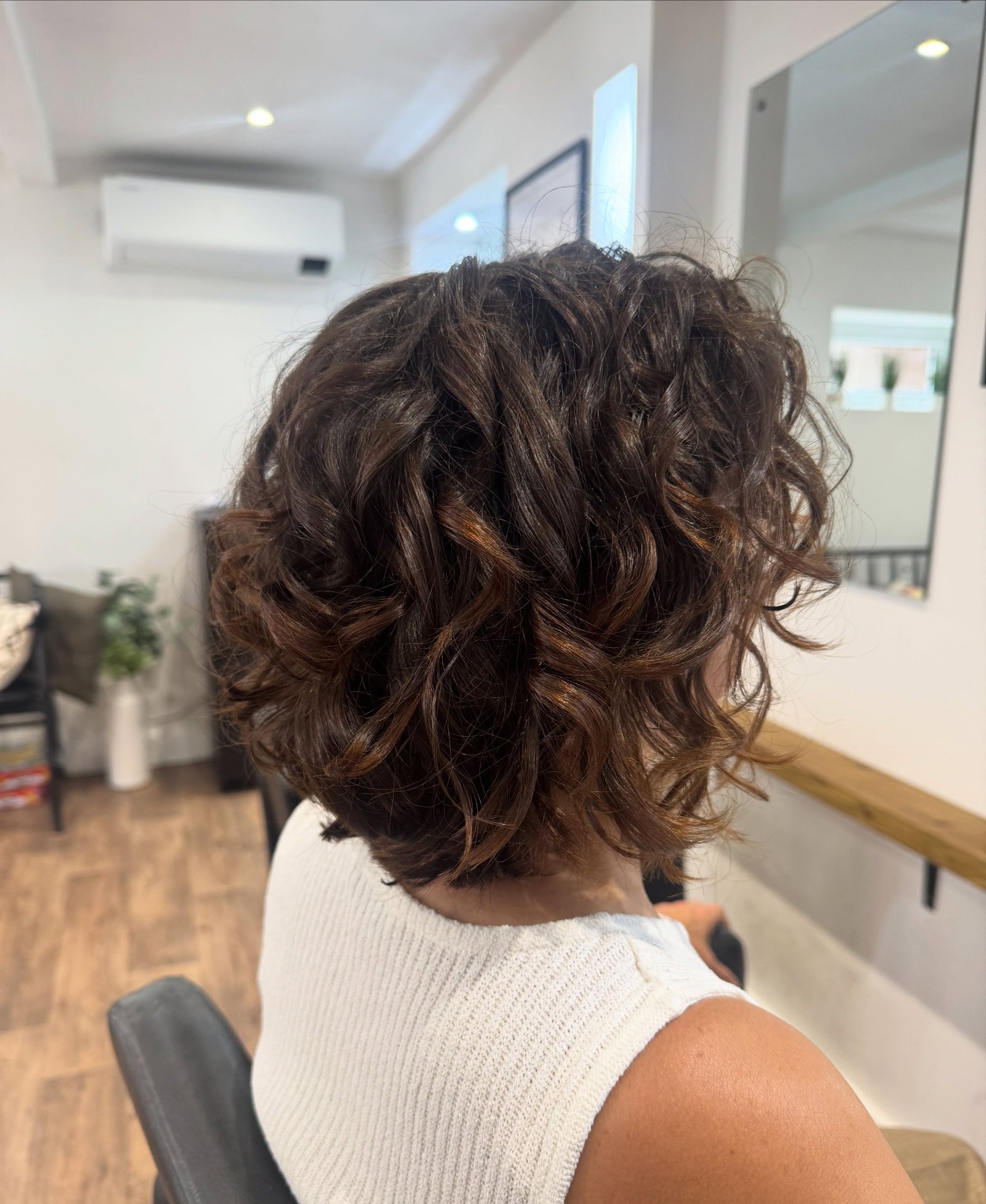 Rounded short bob with curly waves and full volume through the back