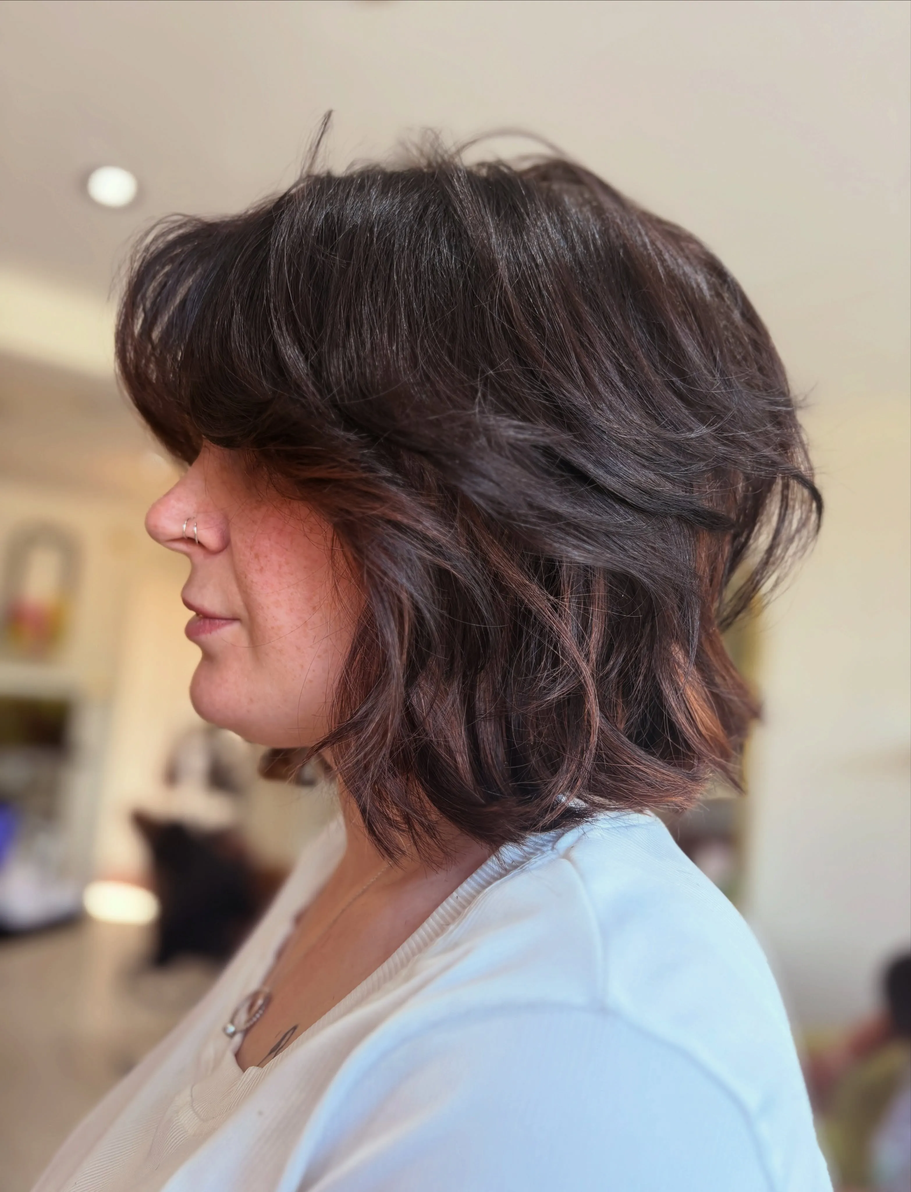 voluminous dark wavy lob with side-swept layers and rounded movement