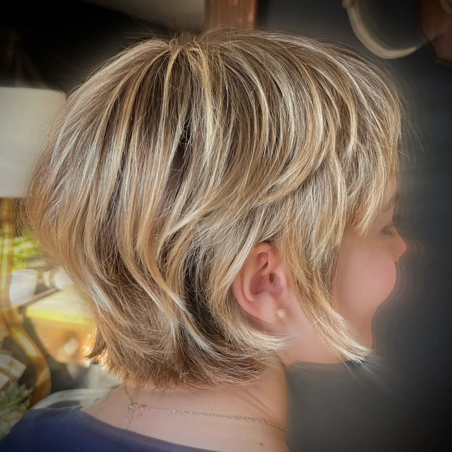 feathered blonde pixie bob with long side fringe and layered nape