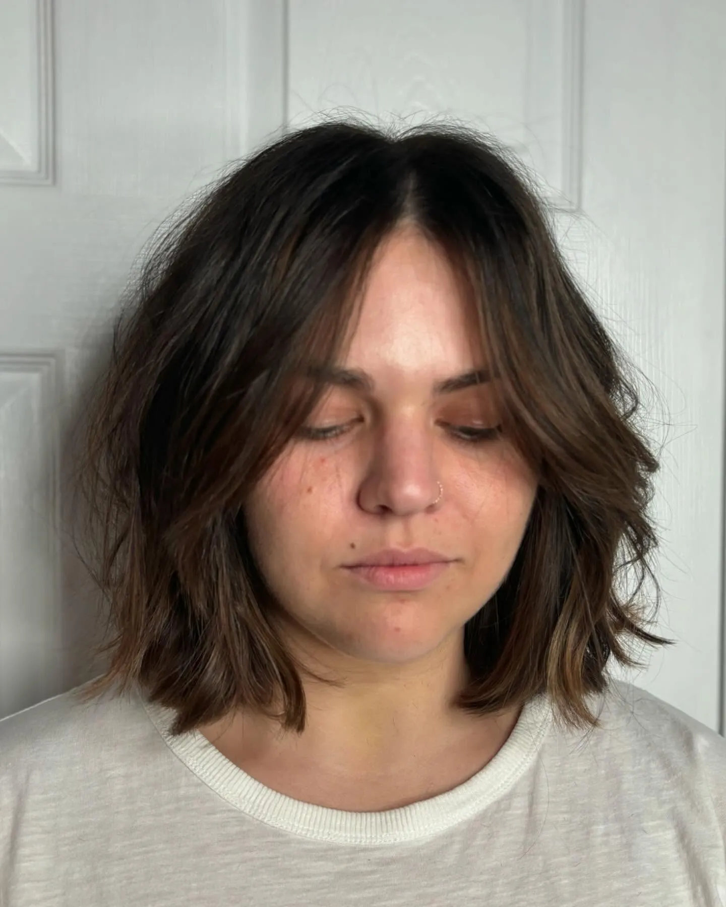 layered dark lob with long curtain bangs and softly flicked ends