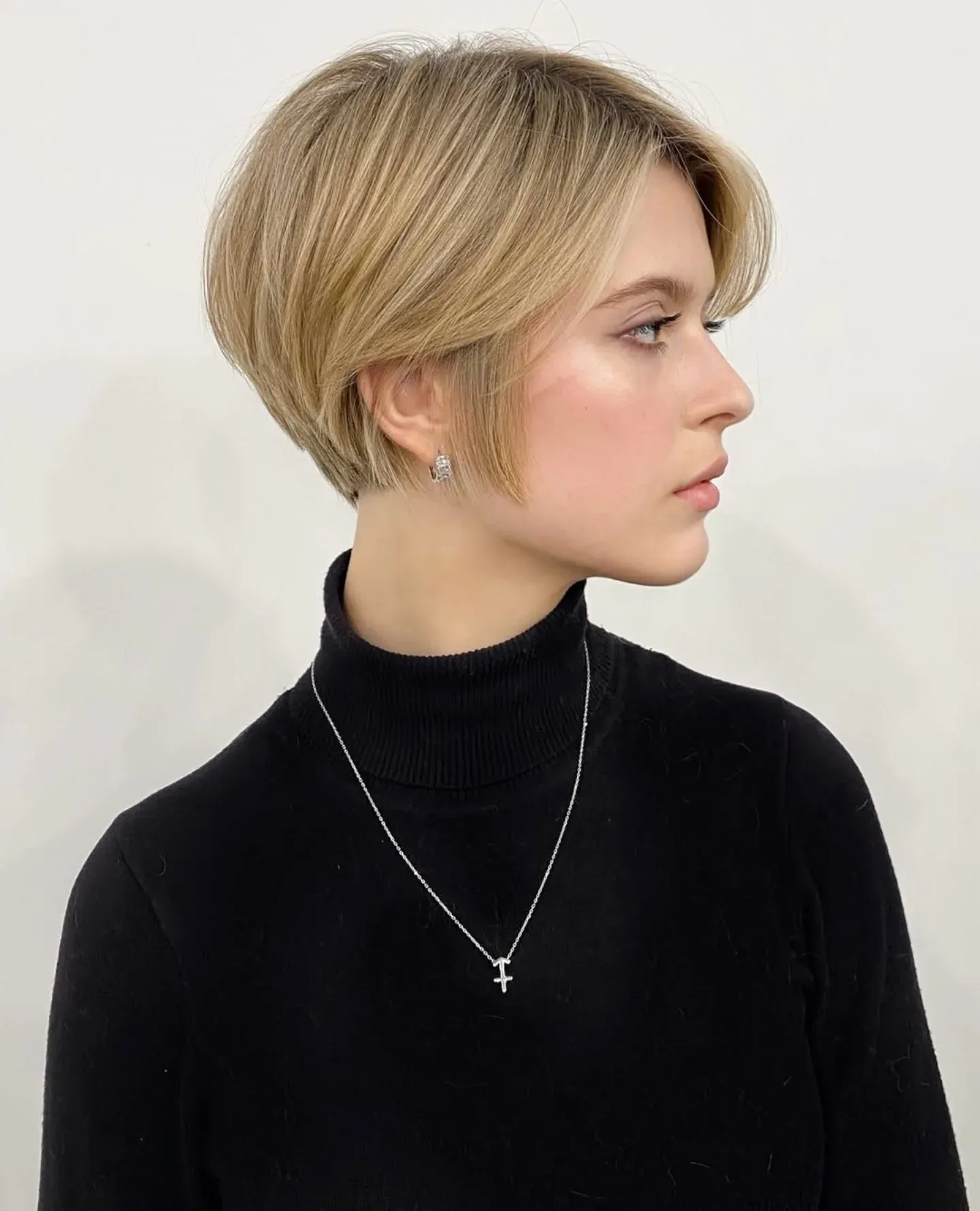 tapered blonde pixie bob with long curtain fringe and rounded back