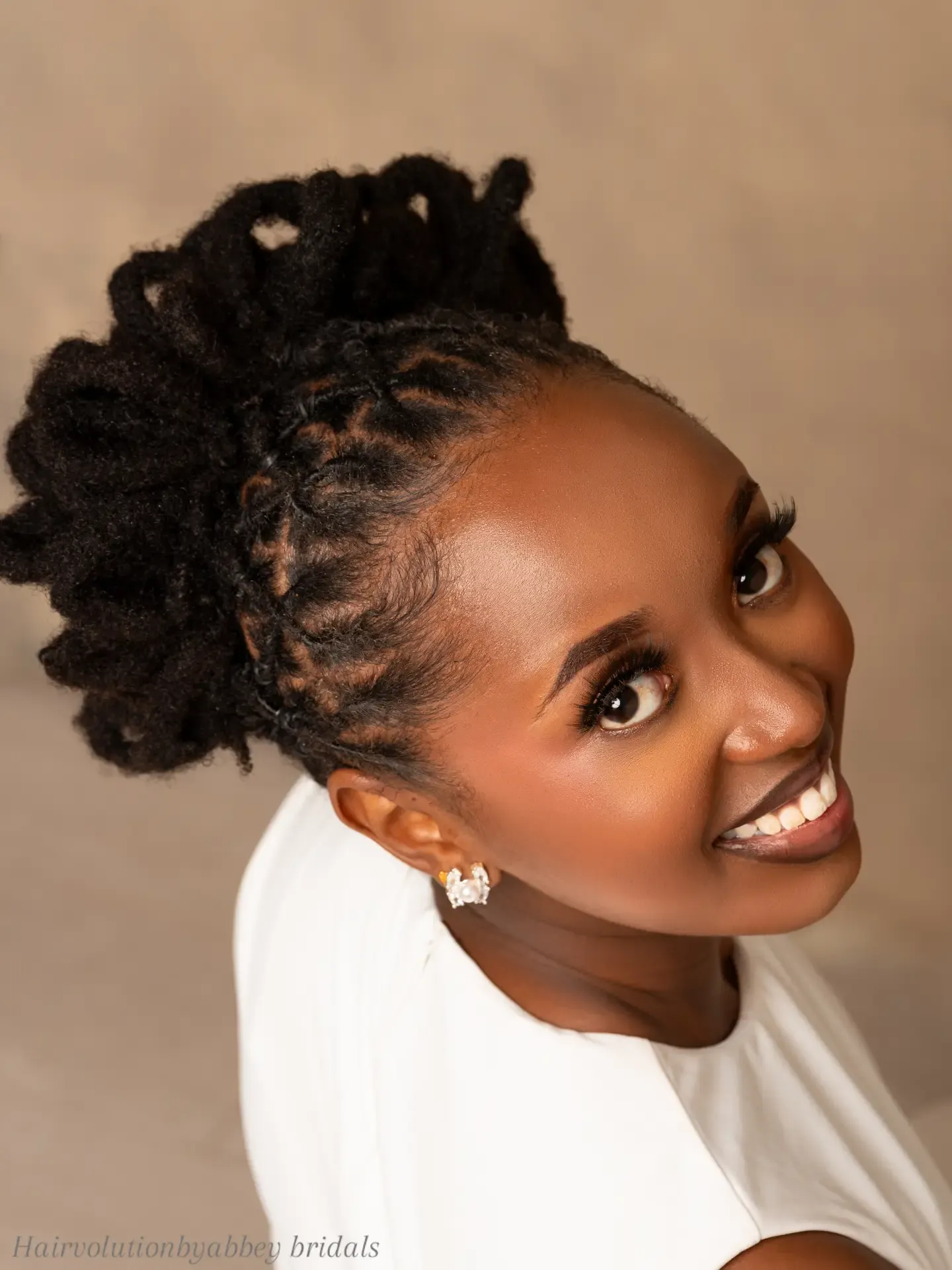 Braided mohawk bridal updo with sculpted side cornrows and textured puff sections
