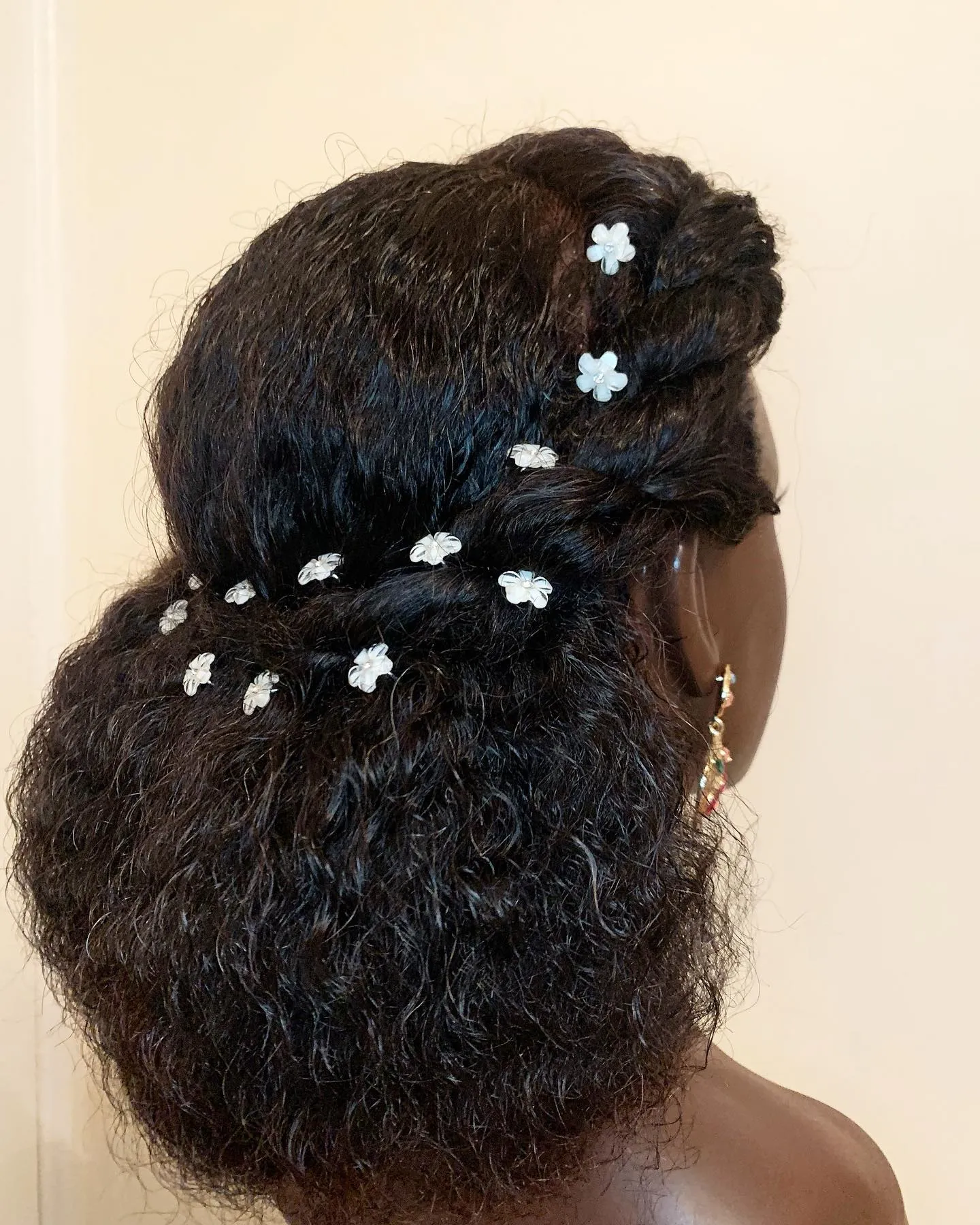 Twisted low bridal puff with smooth side sections and scattered white flower pins