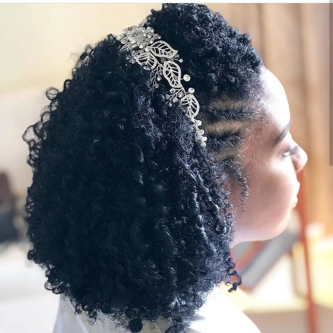Side cornrows with voluminous curly bridal puff and silver leaf hair vine