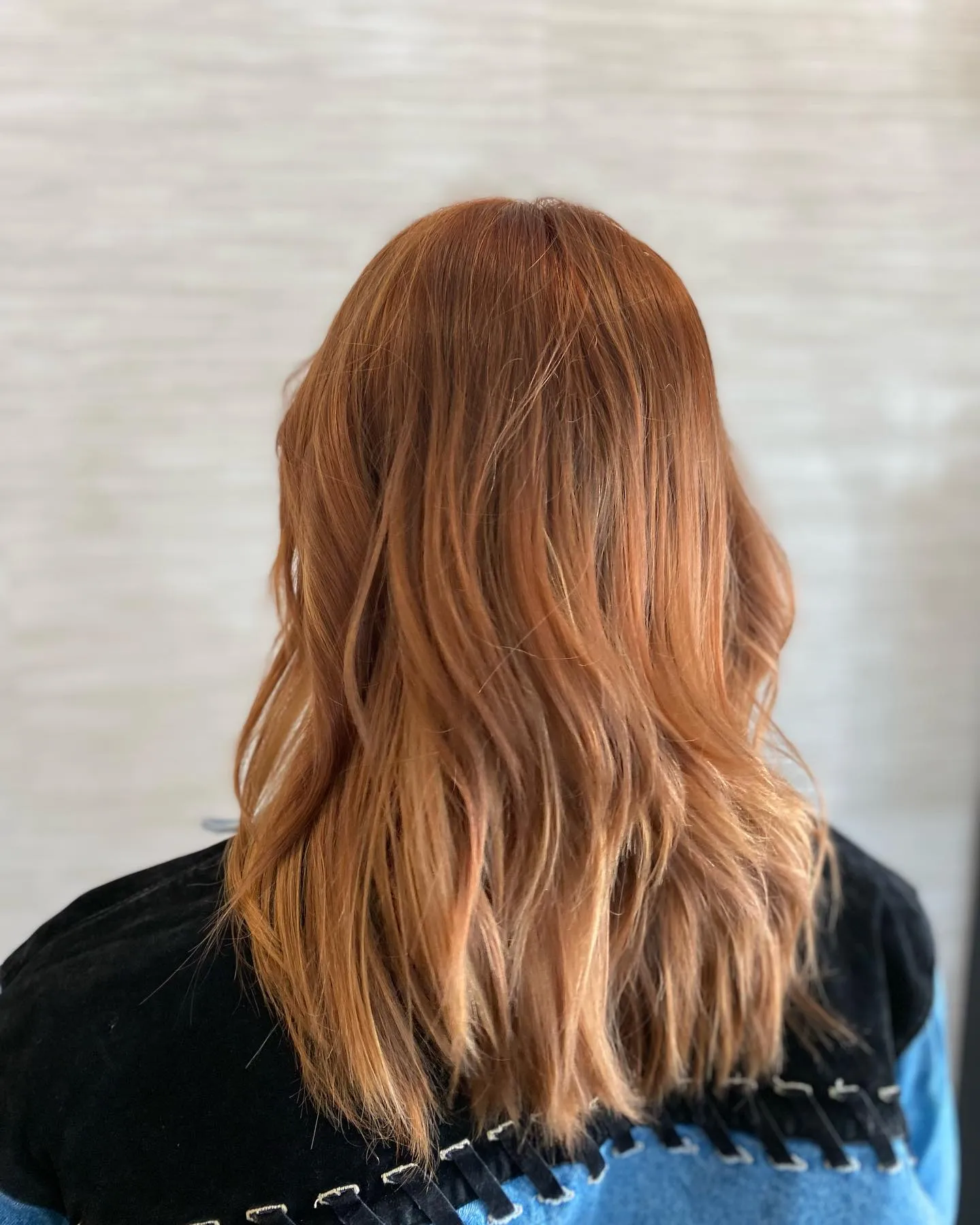 Soft amber balayage on shoulder-length wavy hair