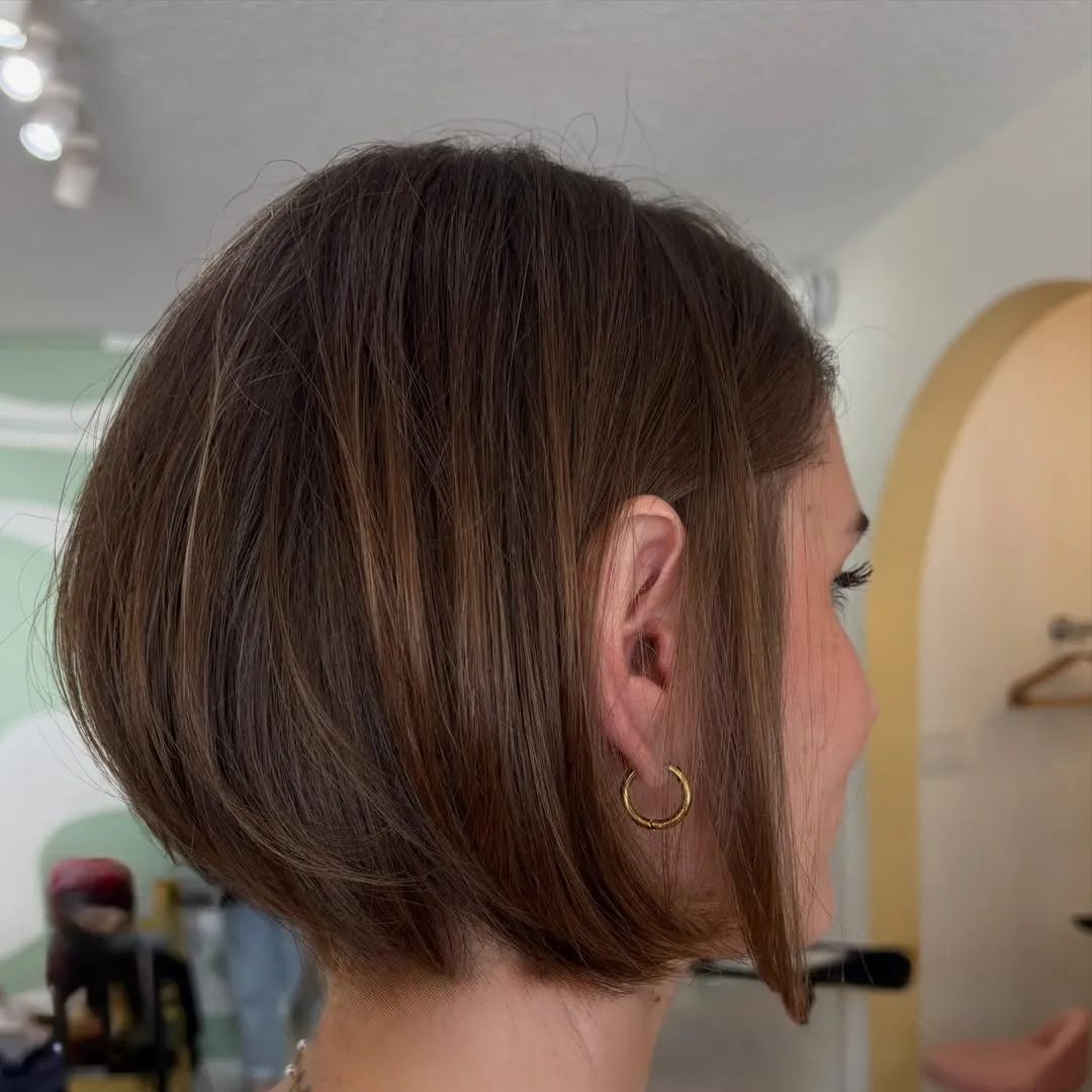 Brunette angled bob tucked behind one ear