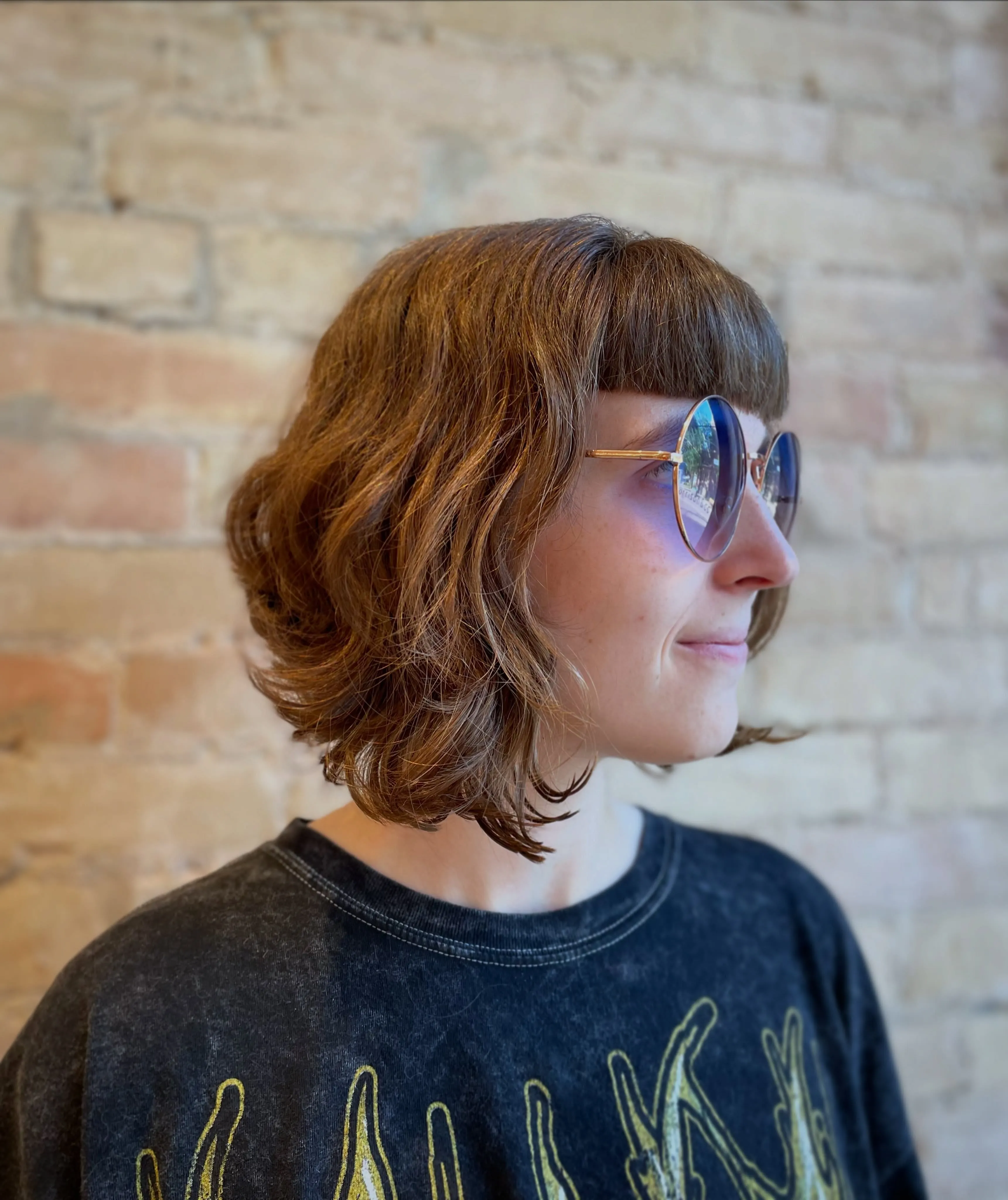 Short curly angled bob with blunt fringe