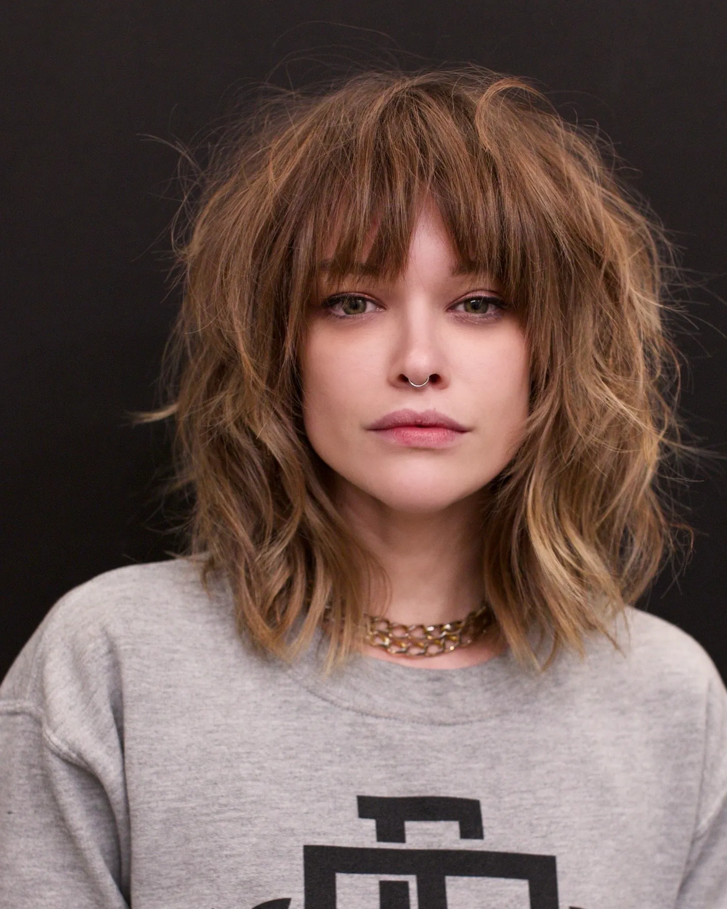 Shaggy shoulder-length hair with full bangs