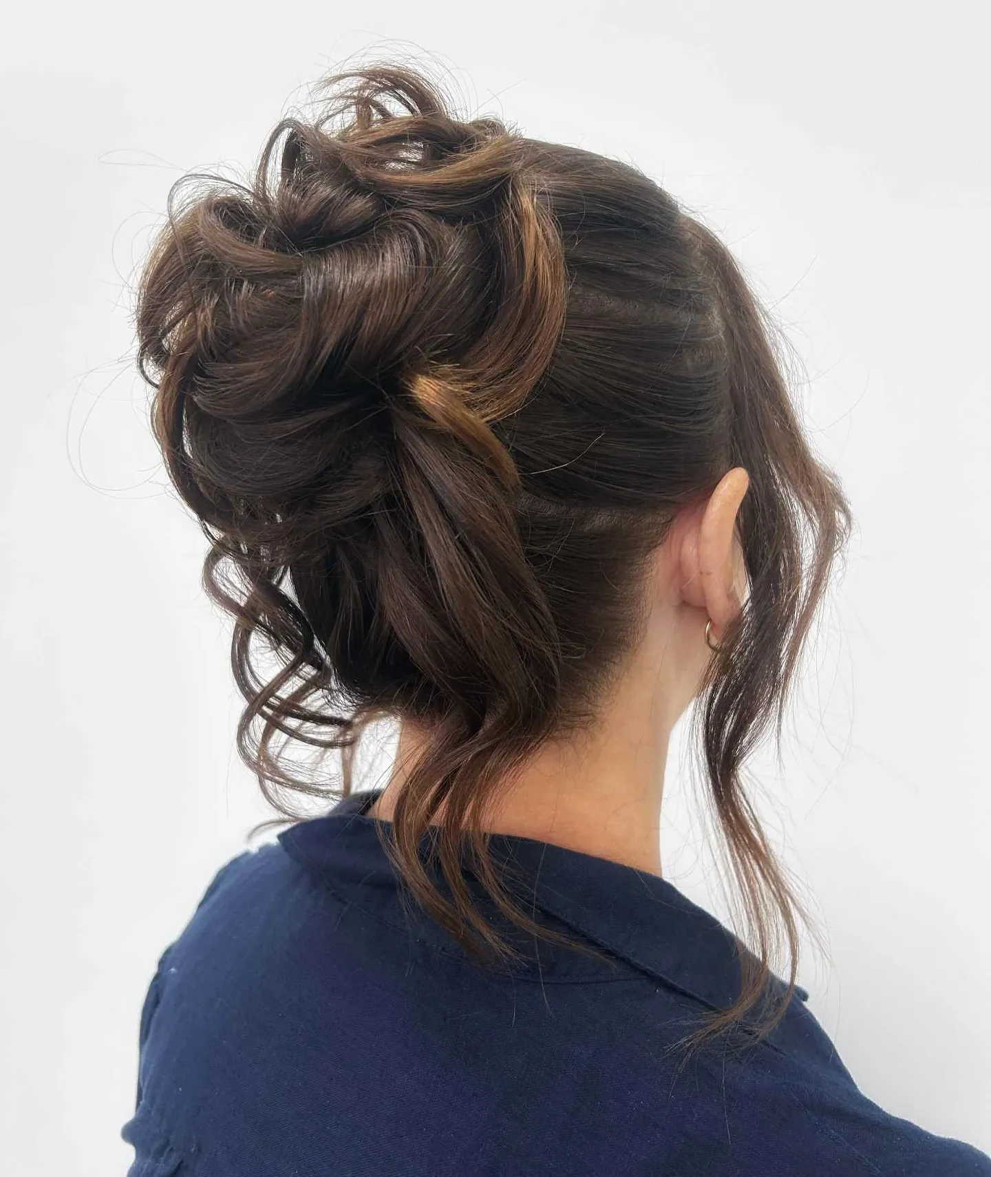 Loose curly updo with face-framing pieces