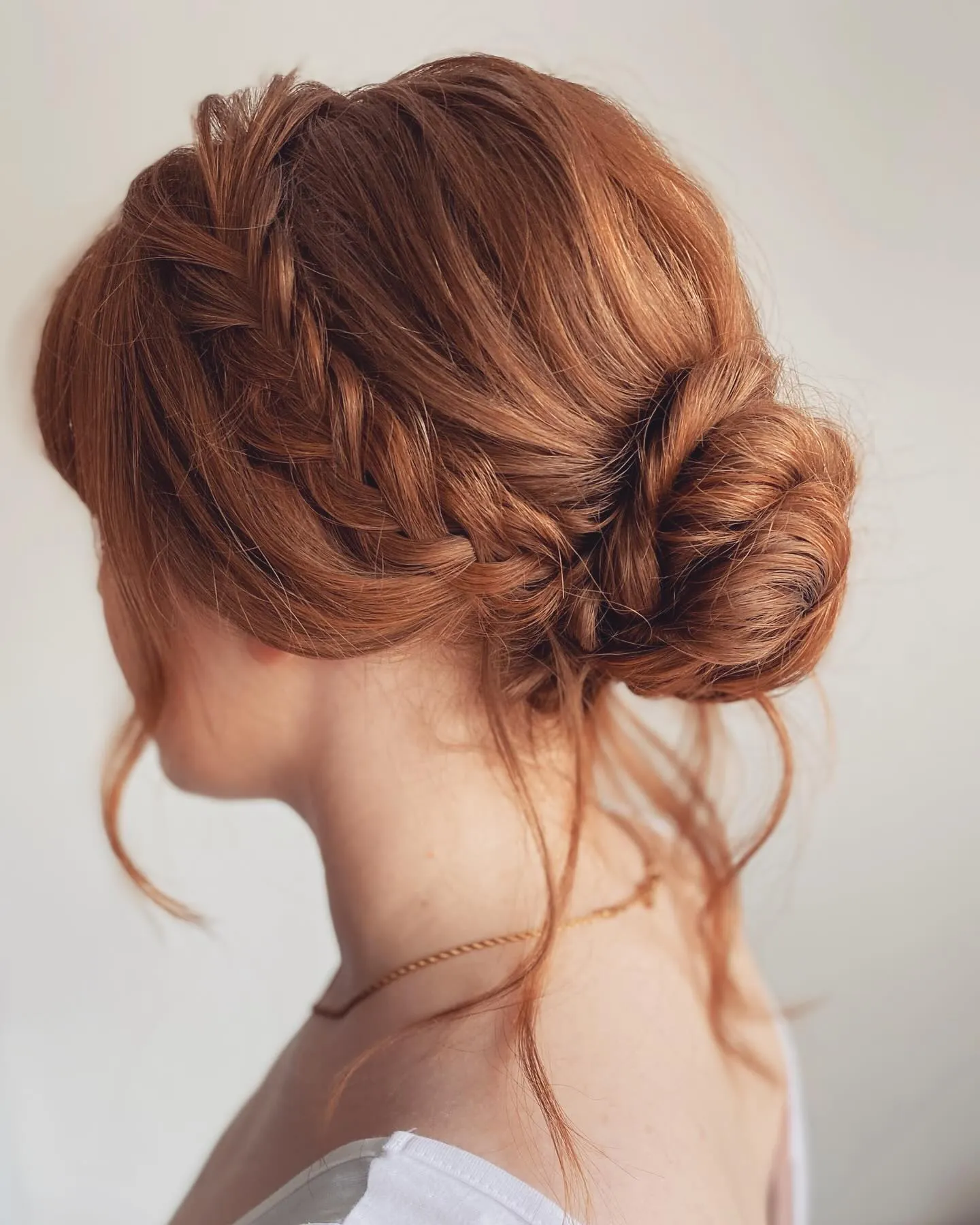 Braided side bun on copper hair