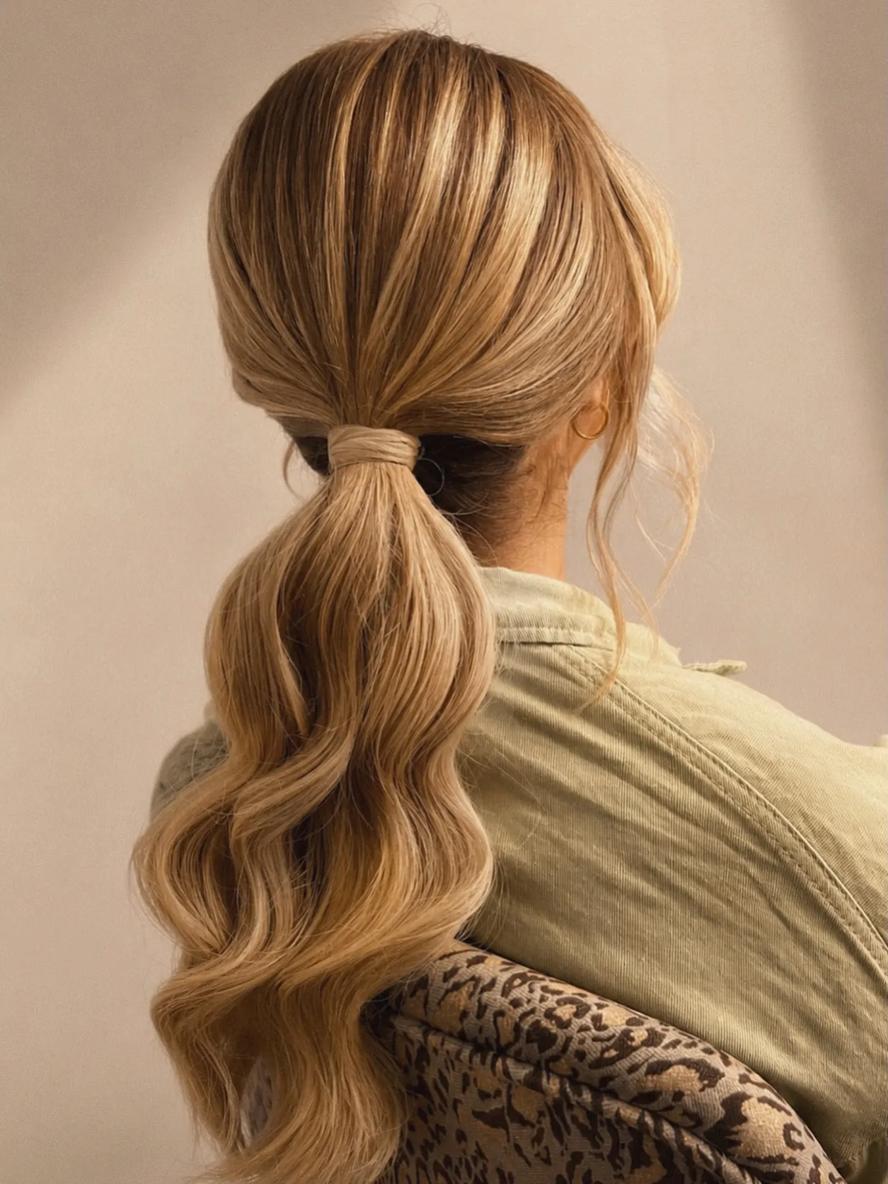 Low blonde ponytail with soft waves and wrapped base