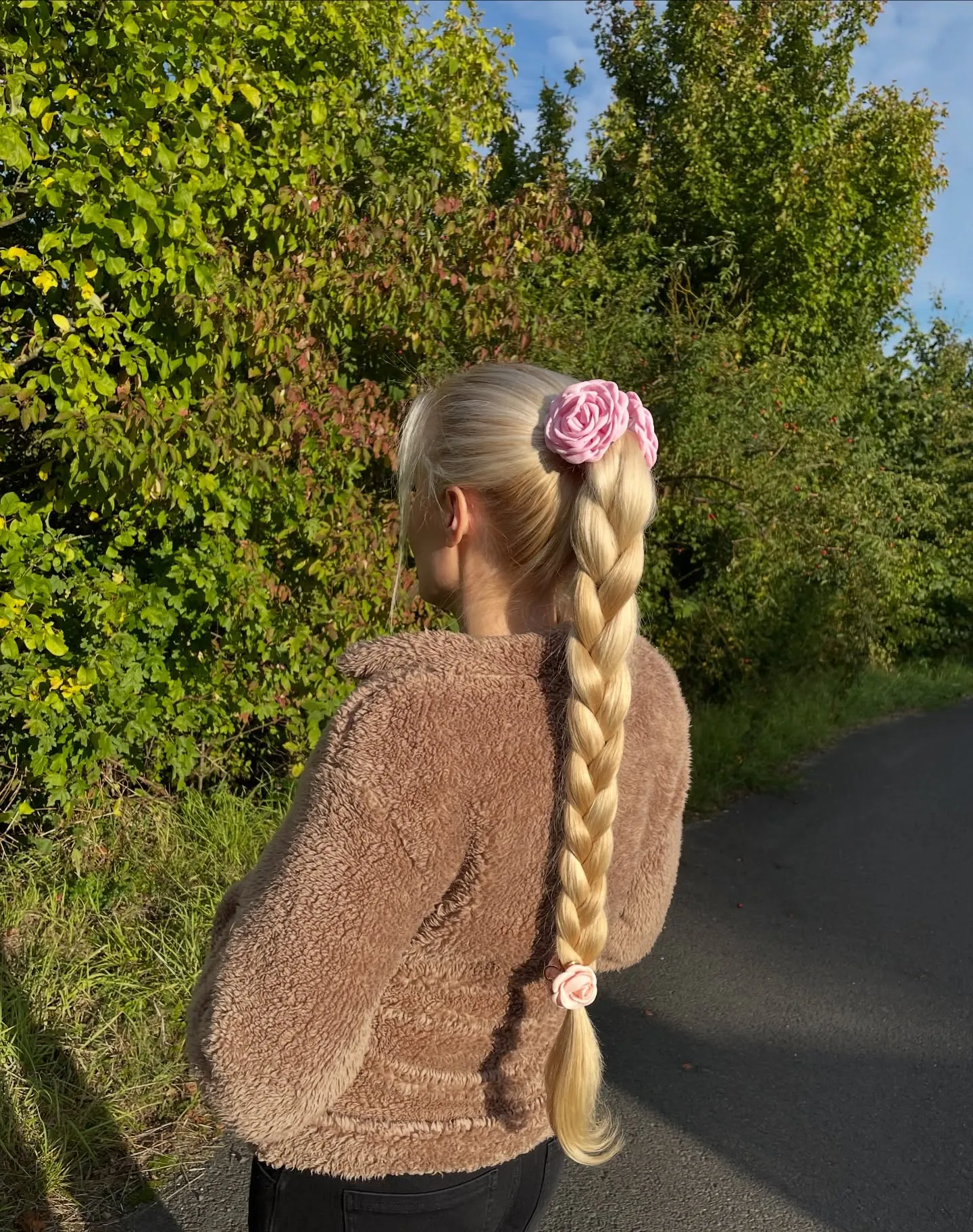 Long blonde braided ponytail with floral accessories