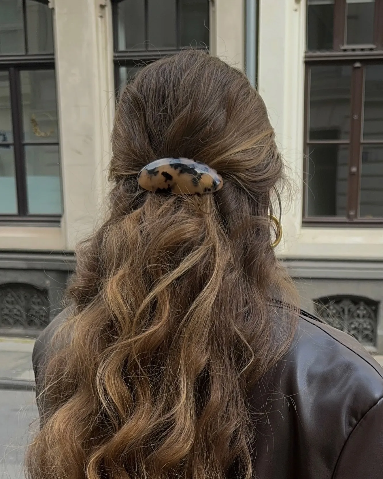 Half-up wavy ponytail secured with a hair clip
