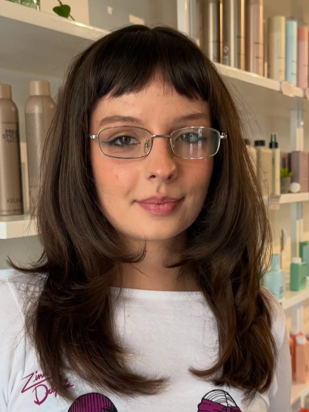 Layered mid-length haircut with straight baby bangs