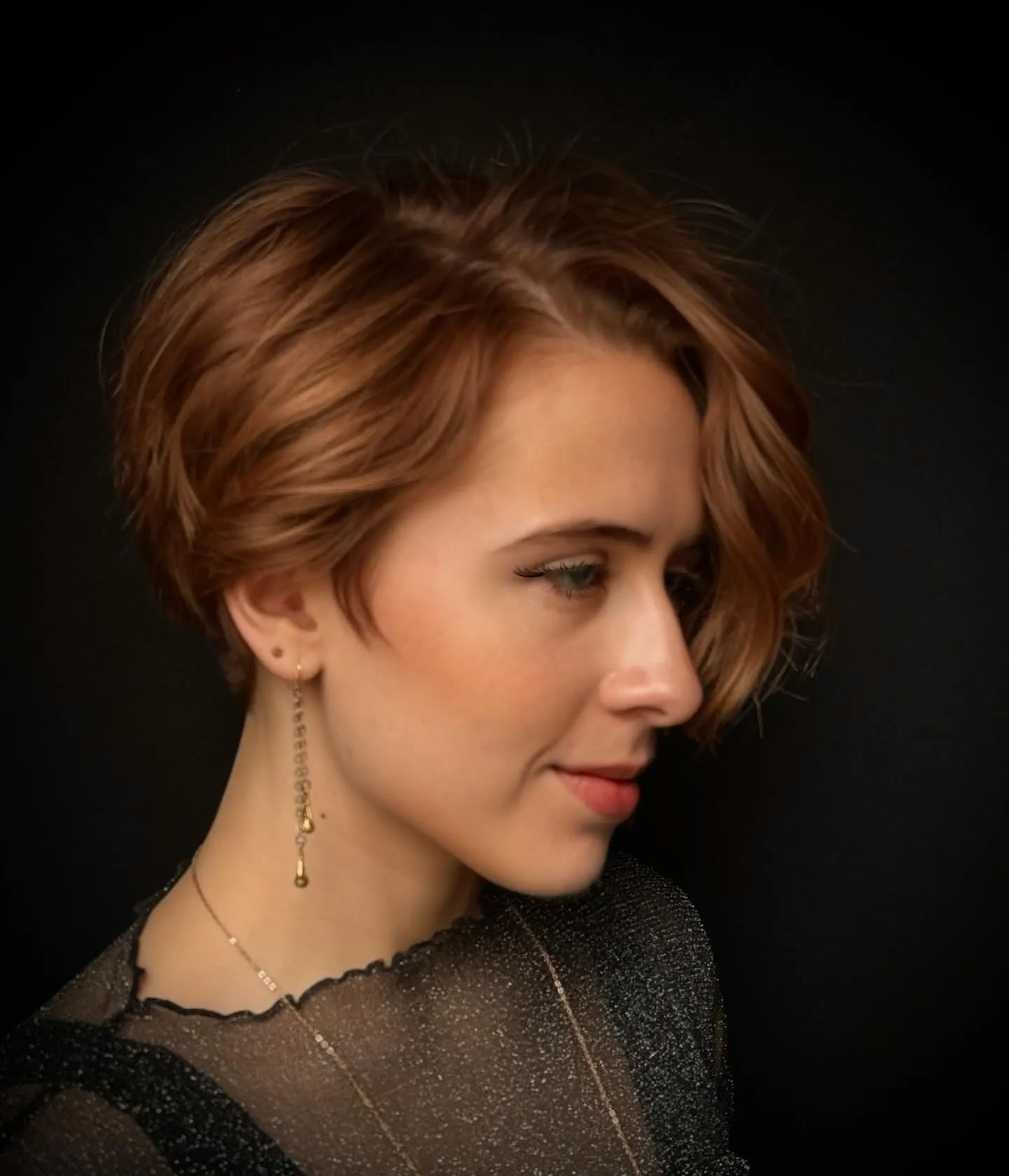 Short auburn bob with side-swept waves and curved ends