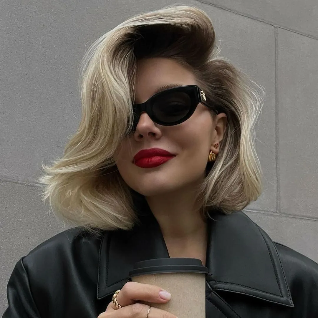 Blonde bob with deep side part and large brushed-out waves