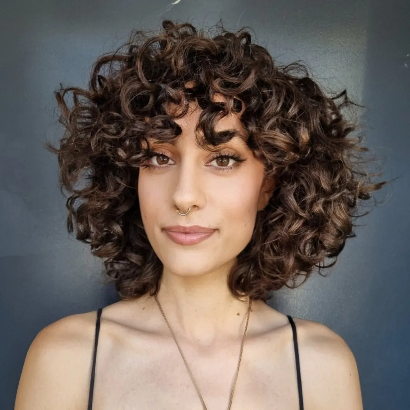 Dark curly rounded bob with full curly fringe