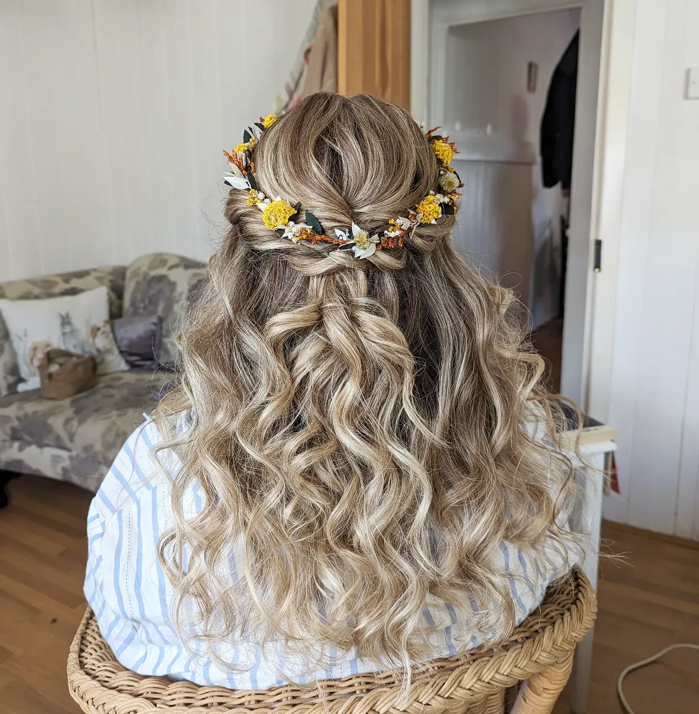 Floral half-up hairstyle with loose blonde waves and tiny flowers