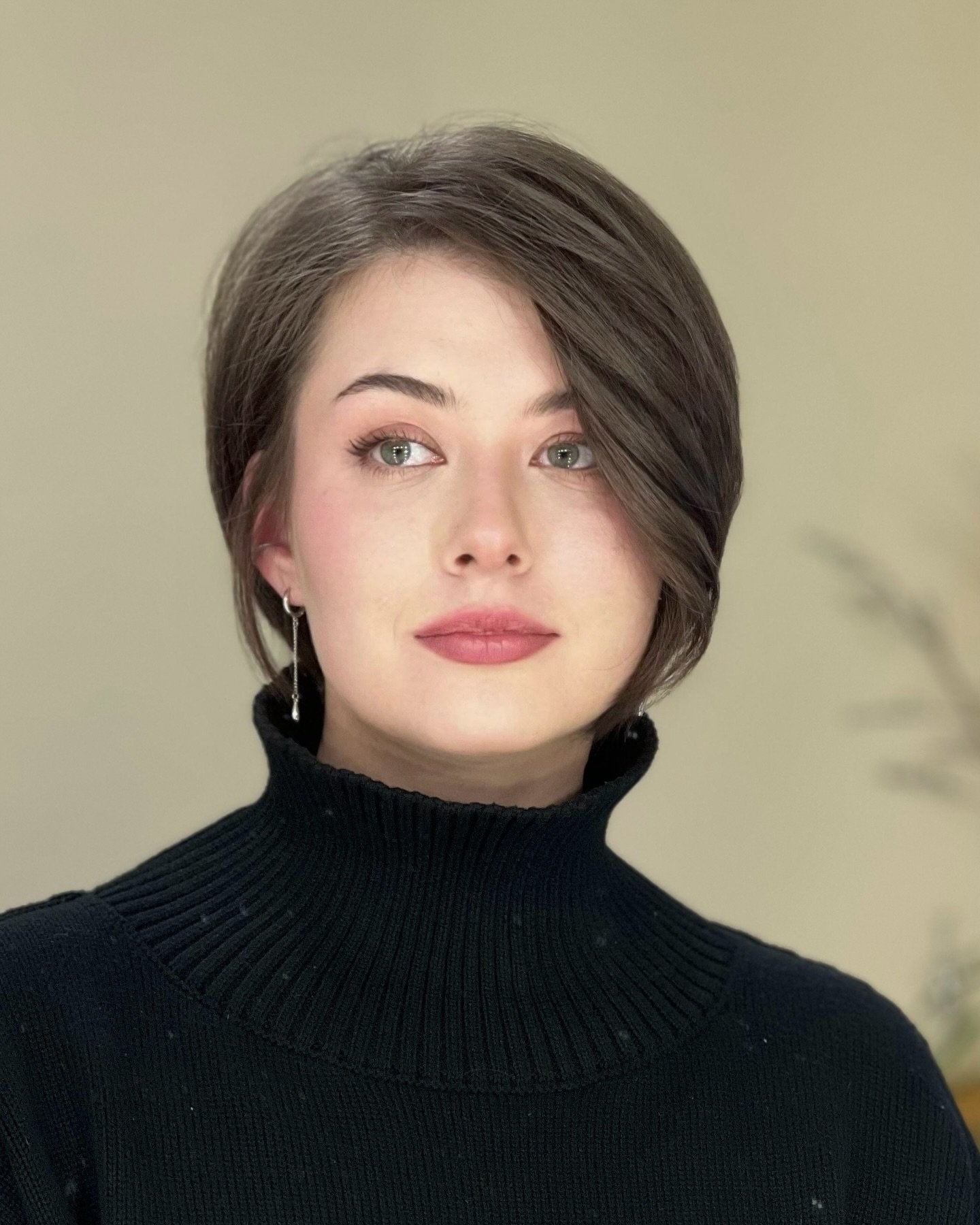 Sleek dark asymmetrical bixie with a long side fringe and tucked short side