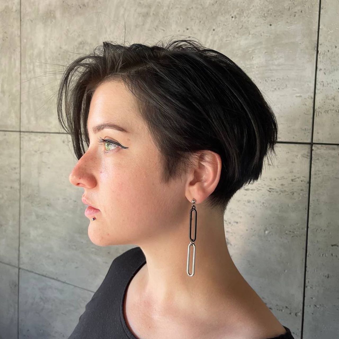 Rounded black bixie with a deep side-swept fringe and short nape