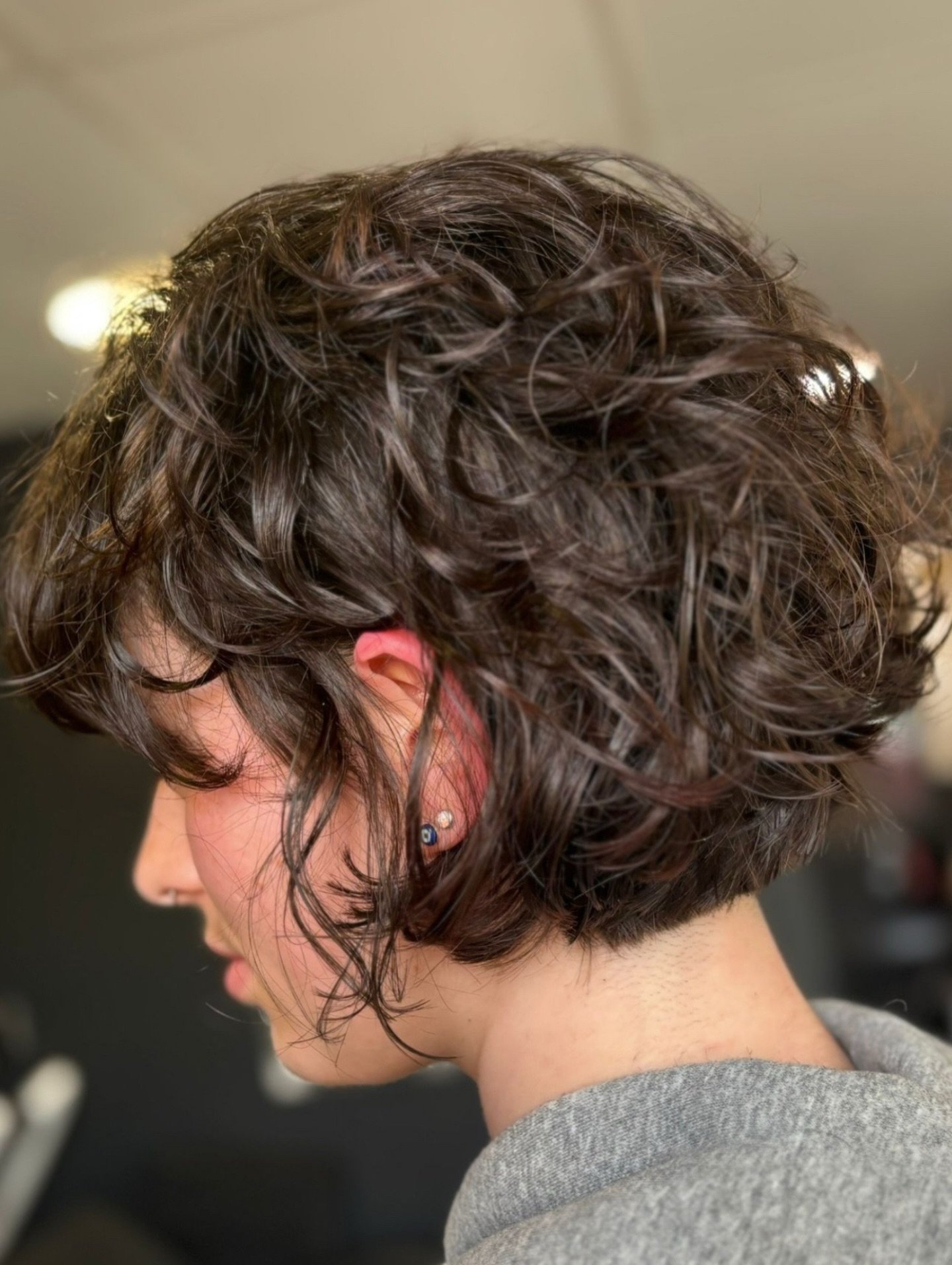 Curly dark bixie with a rounded back and loose face-framing pieces