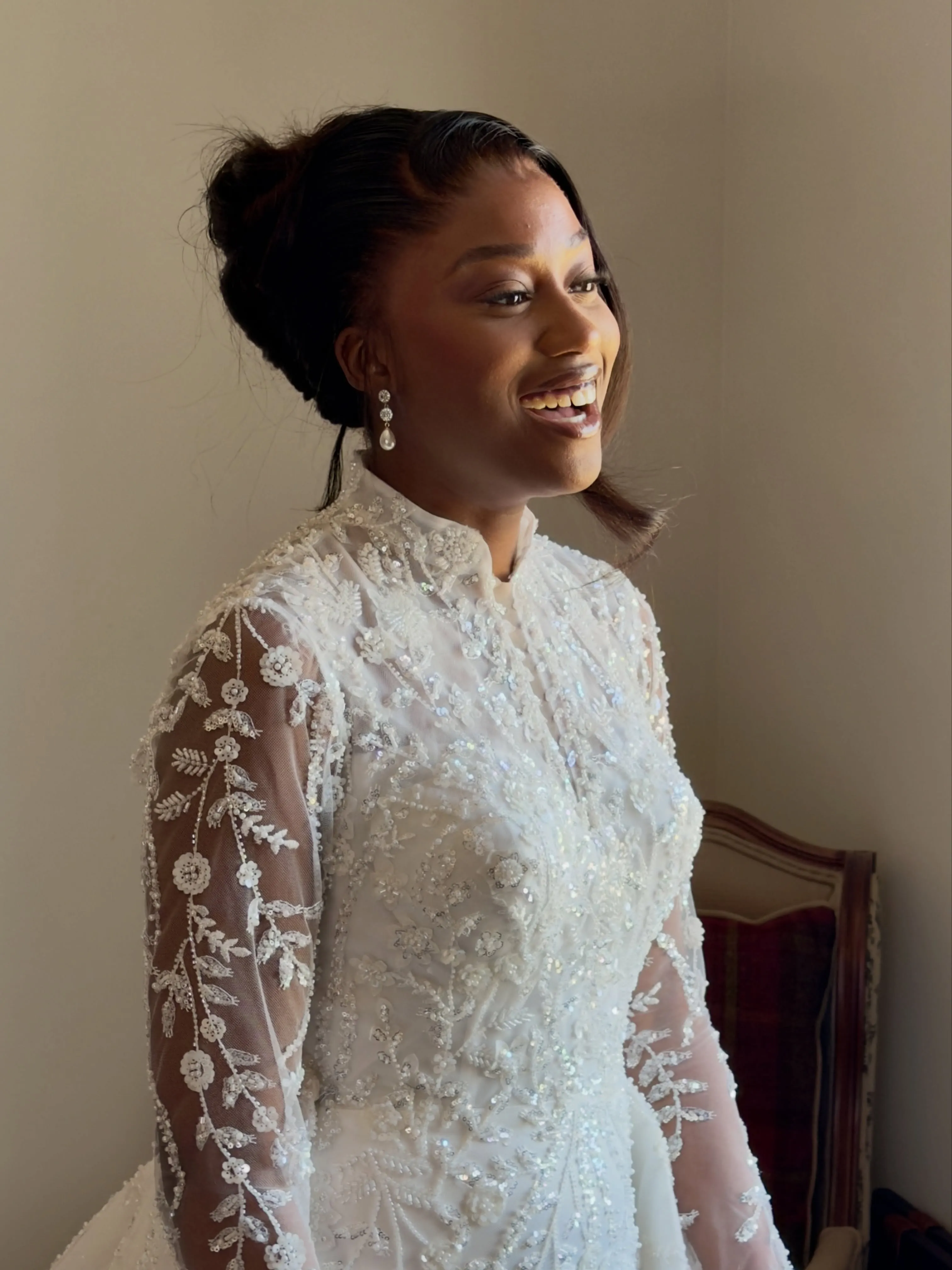 Soft low bridal bun with side part and loose face-framing strand