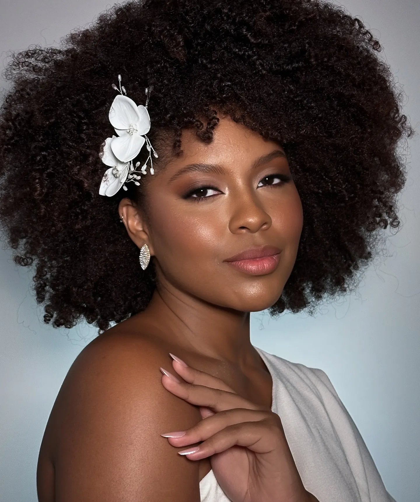 Natural bridal afro with a white floral hair accessory