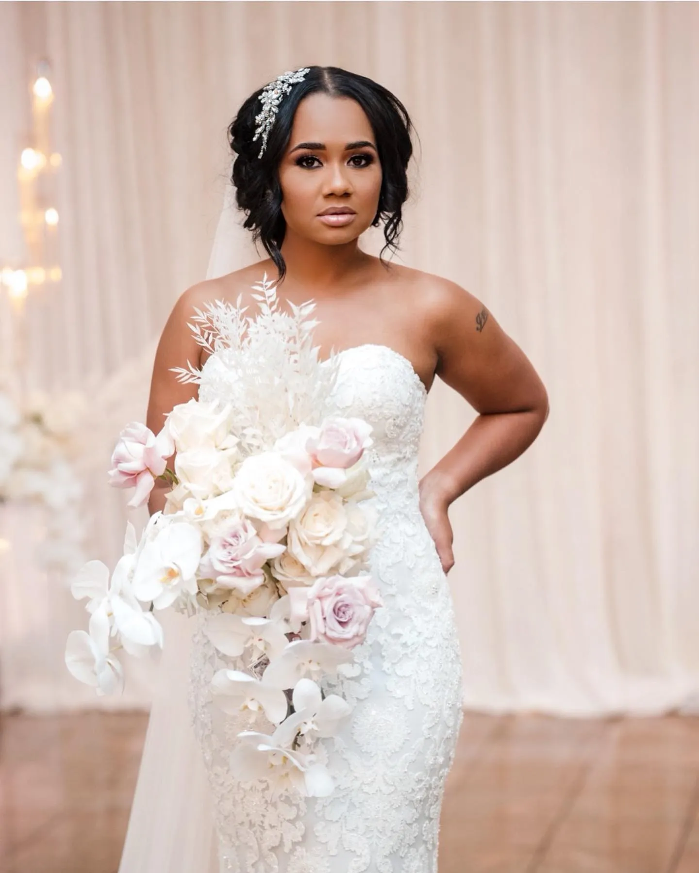 Centre-parted bridal updo with loose curls and a crystal side comb