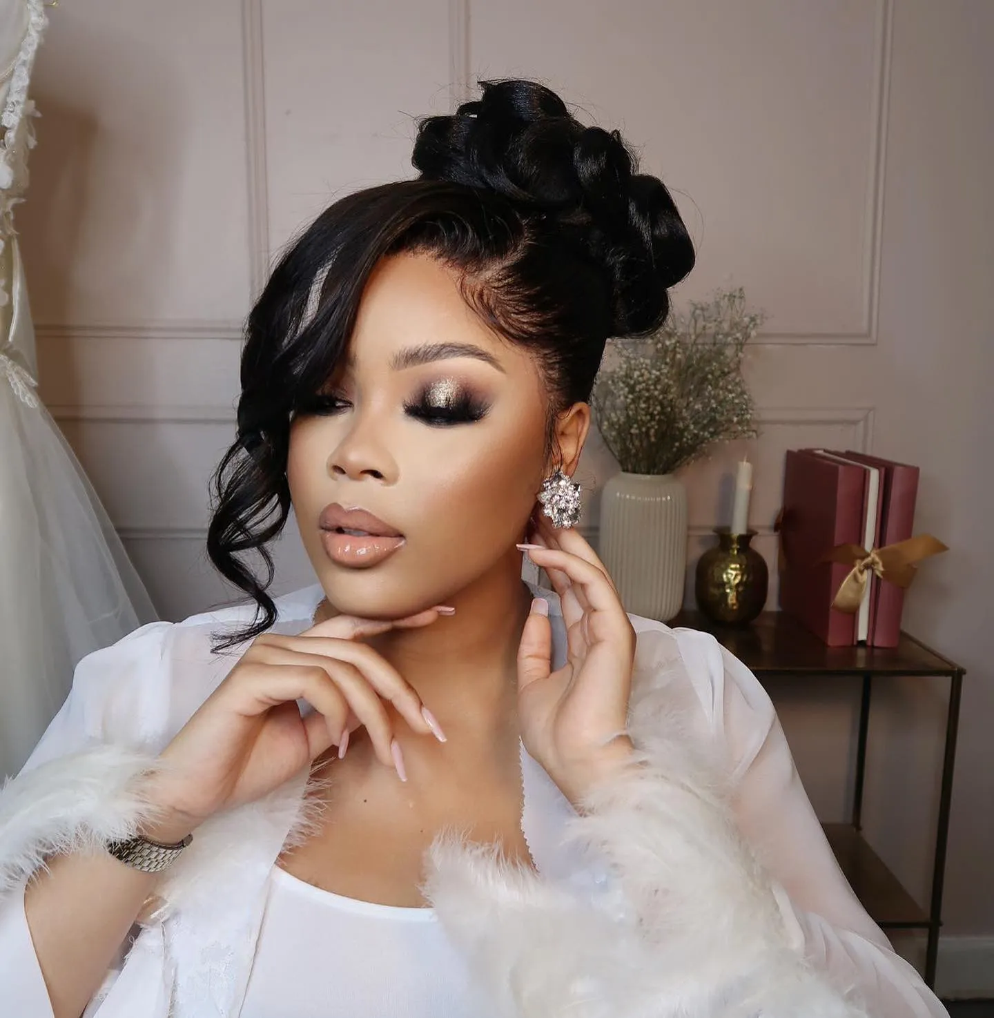 Bridal top bun with a deep side fringe and loose curl