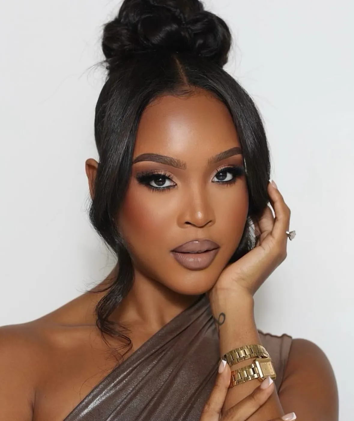 High bridal bun with centre-parted face-framing pieces