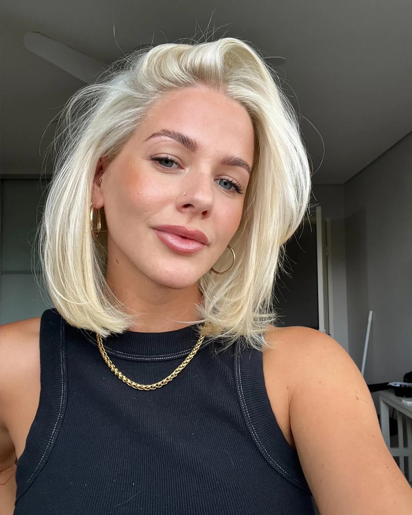 Voluminous blonde bob with side part and curved ends