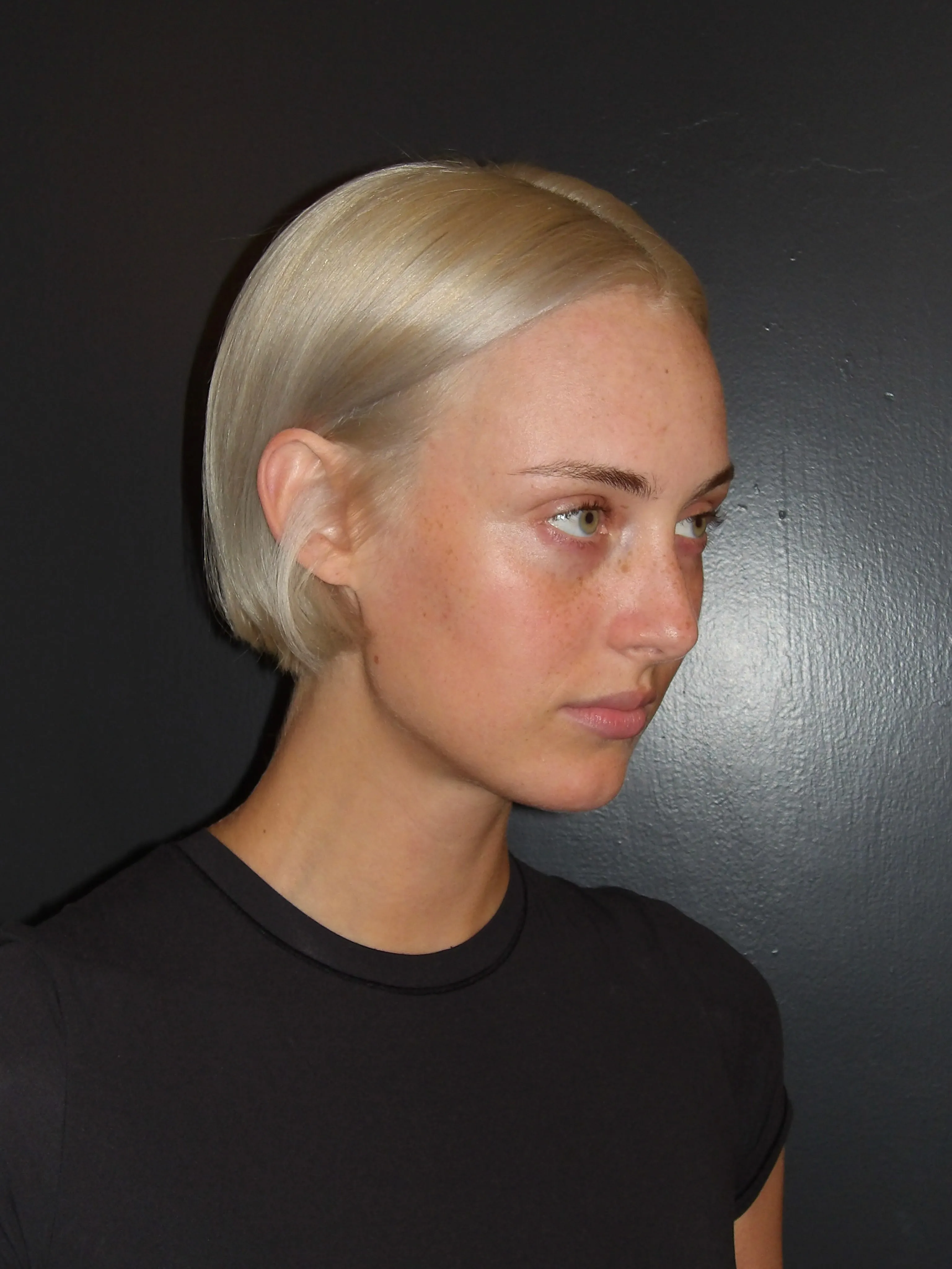 Sleek tucked blonde bob with side part