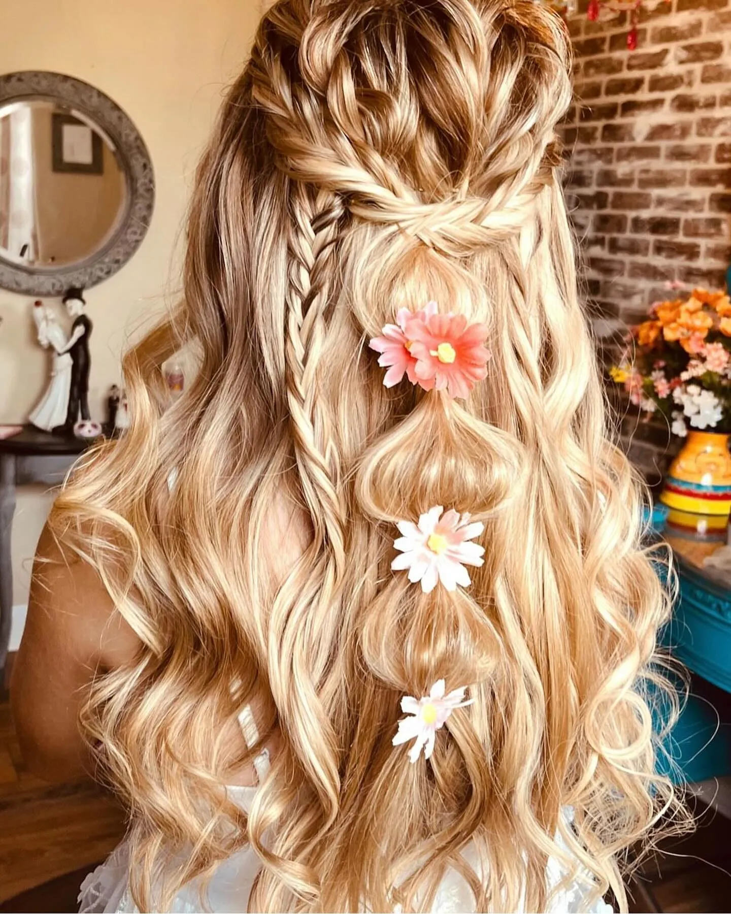 Half-up crown braid with long waves and colourful daisies