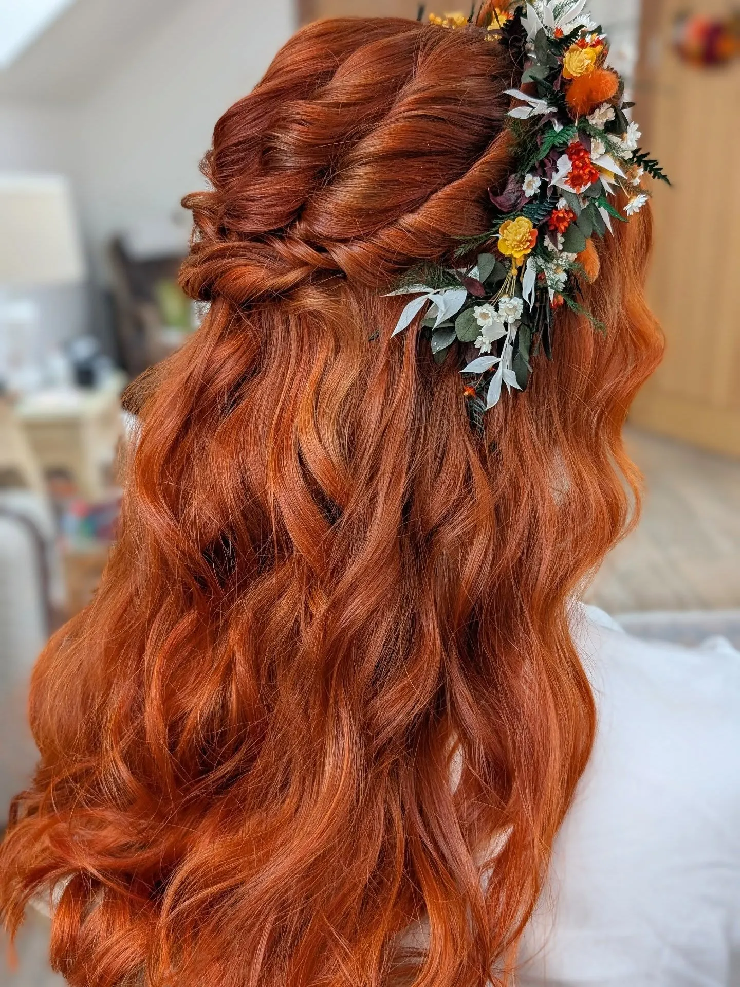 Twisted half-up red bridal waves with a statement flower spray