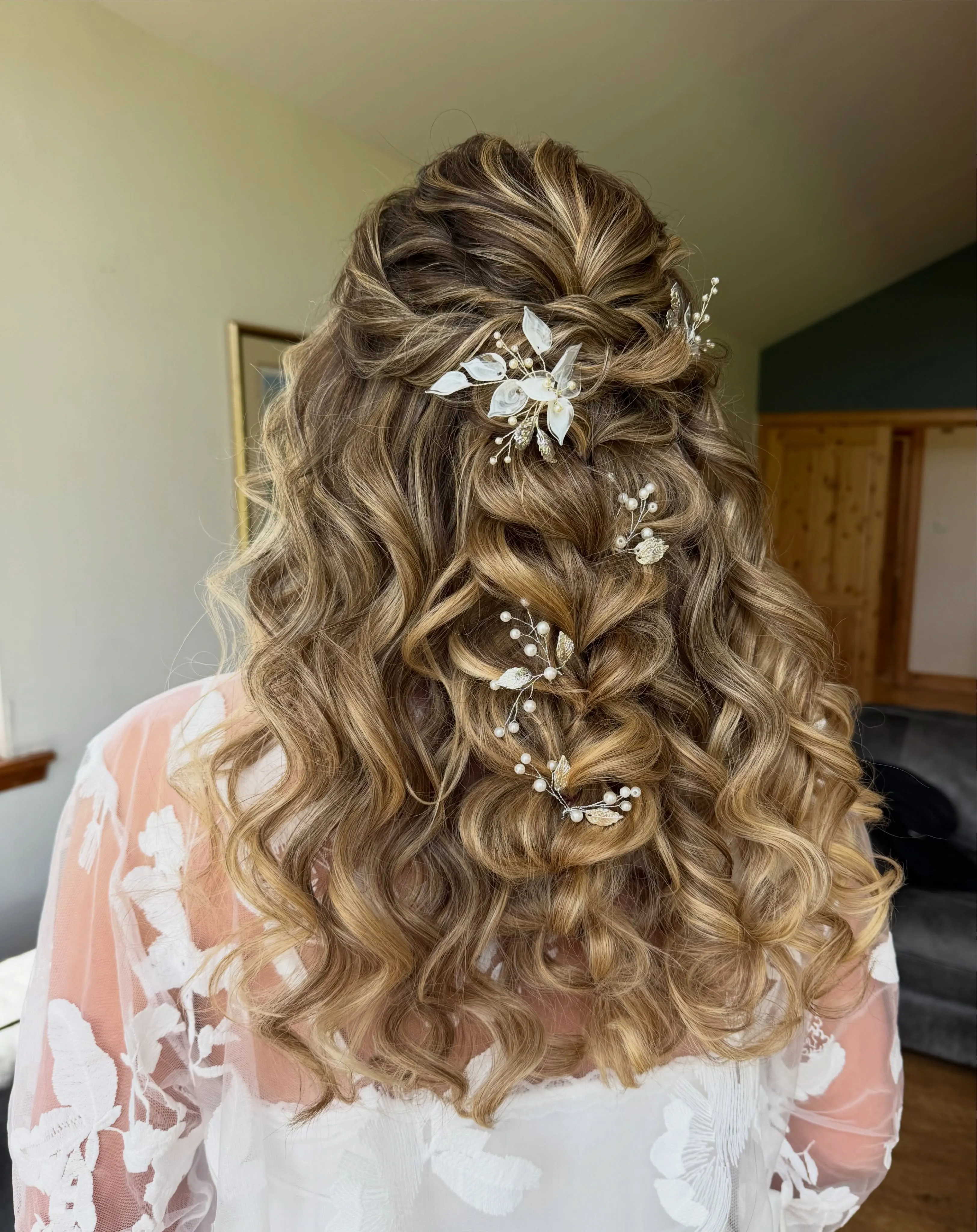 Shoulder-length half-up bridal curls with delicate floral pins