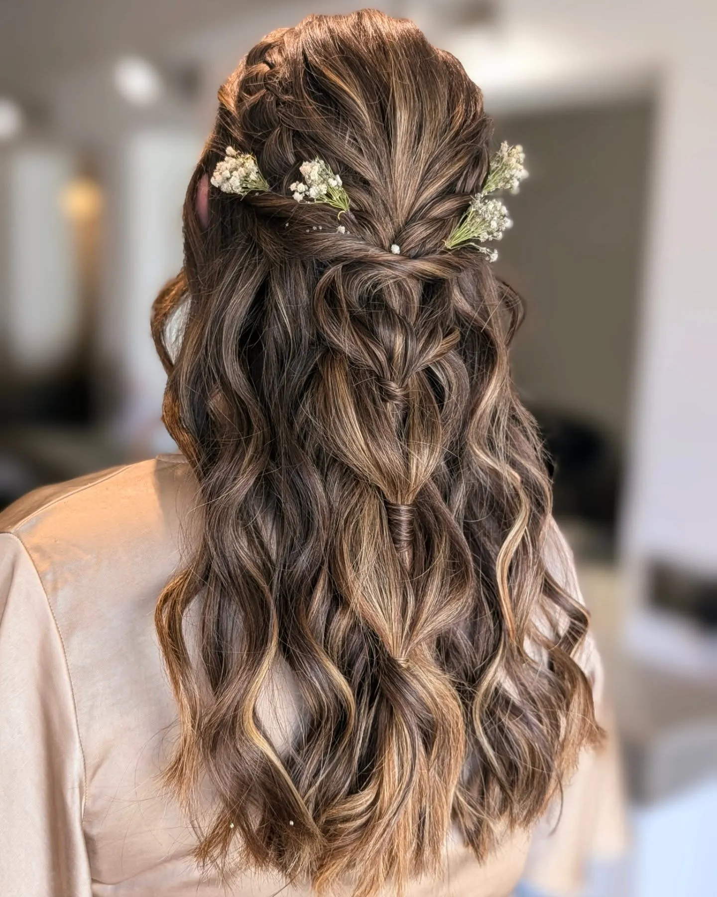 Textured half-up boho bridal braid with loose waves and baby's breath