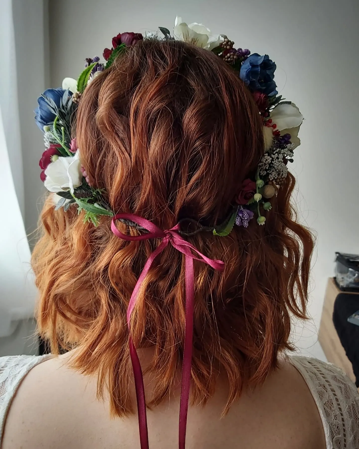 Half-up wavy bridal bob with colourful floral crown and ribbon ties