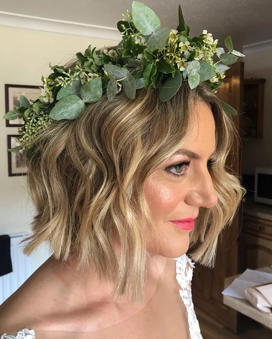 Wavy bridal bob with a full greenery crown and loose face-framing waves