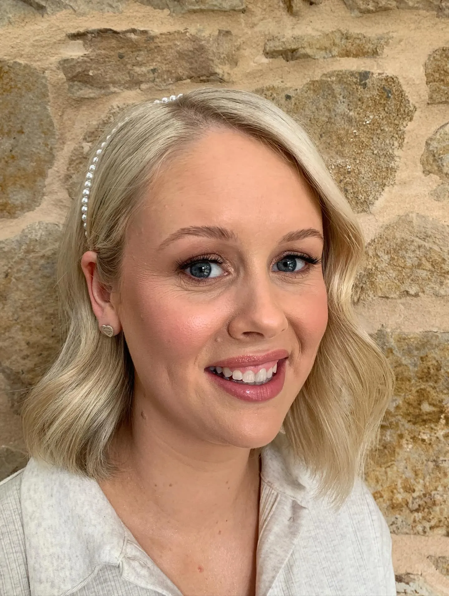 Soft shoulder-length bridal bob with side part, loose waves and a pearl headband