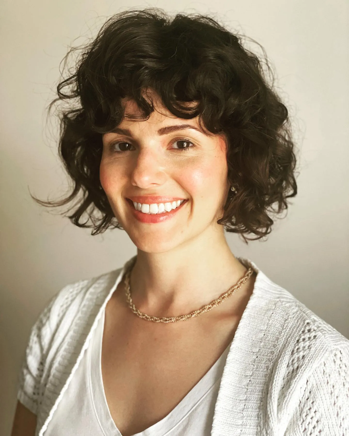 Curly bridal bob with full rounded fringe and natural volume